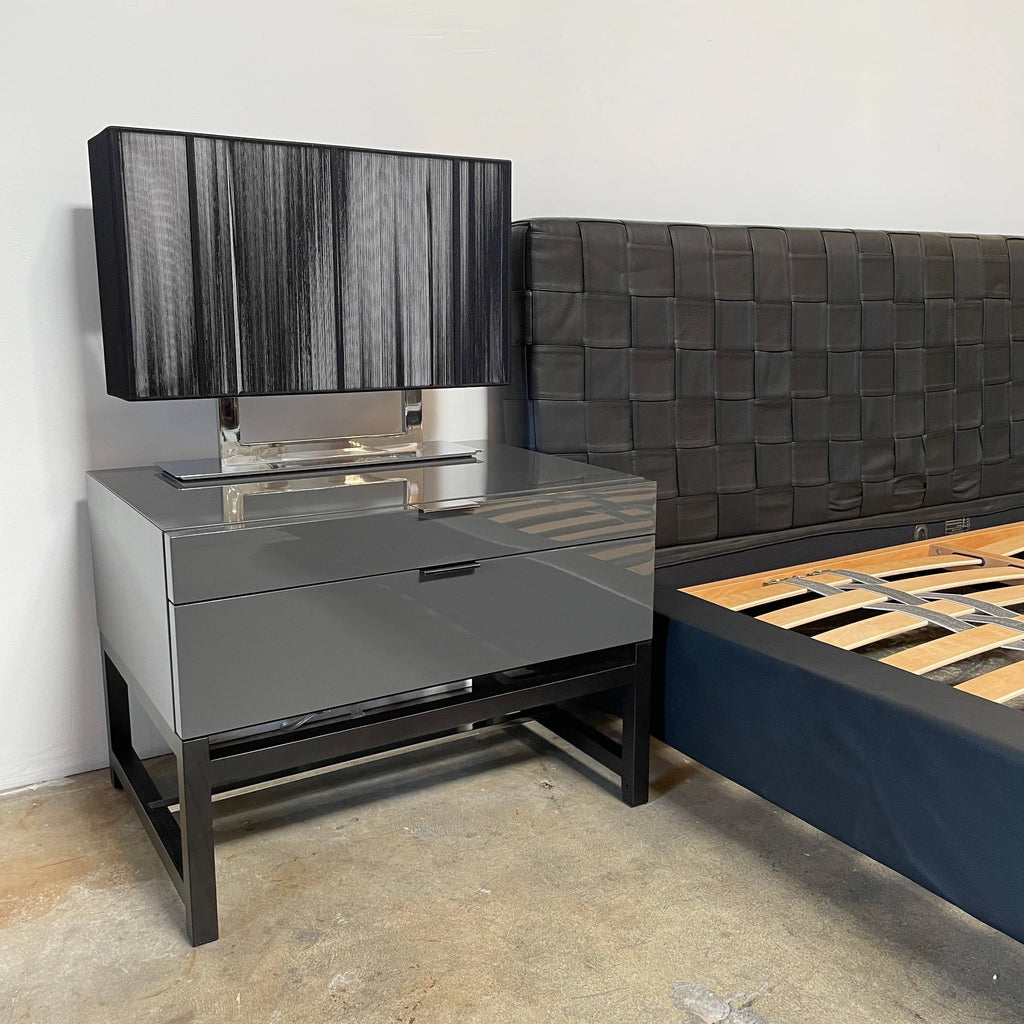 A Minotti Bartlett Cal King Bed with a wooden slatted base.