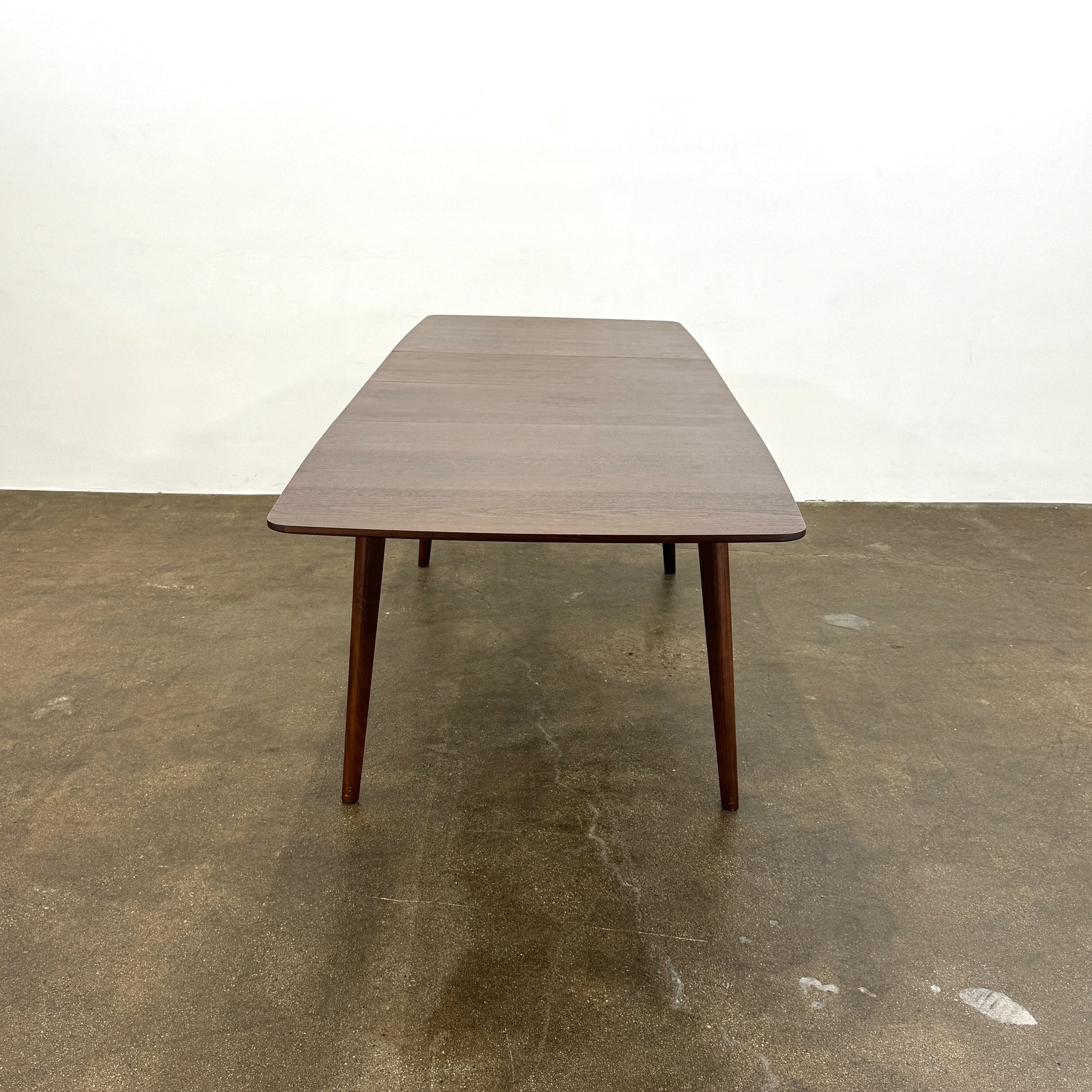 The Case Design Dulwich Extension Table by Case is an elegant rectangular walnut dining table with four legs and a smooth, flat surface, viewed from the front against a plain white background—ideal for modern dining spaces.