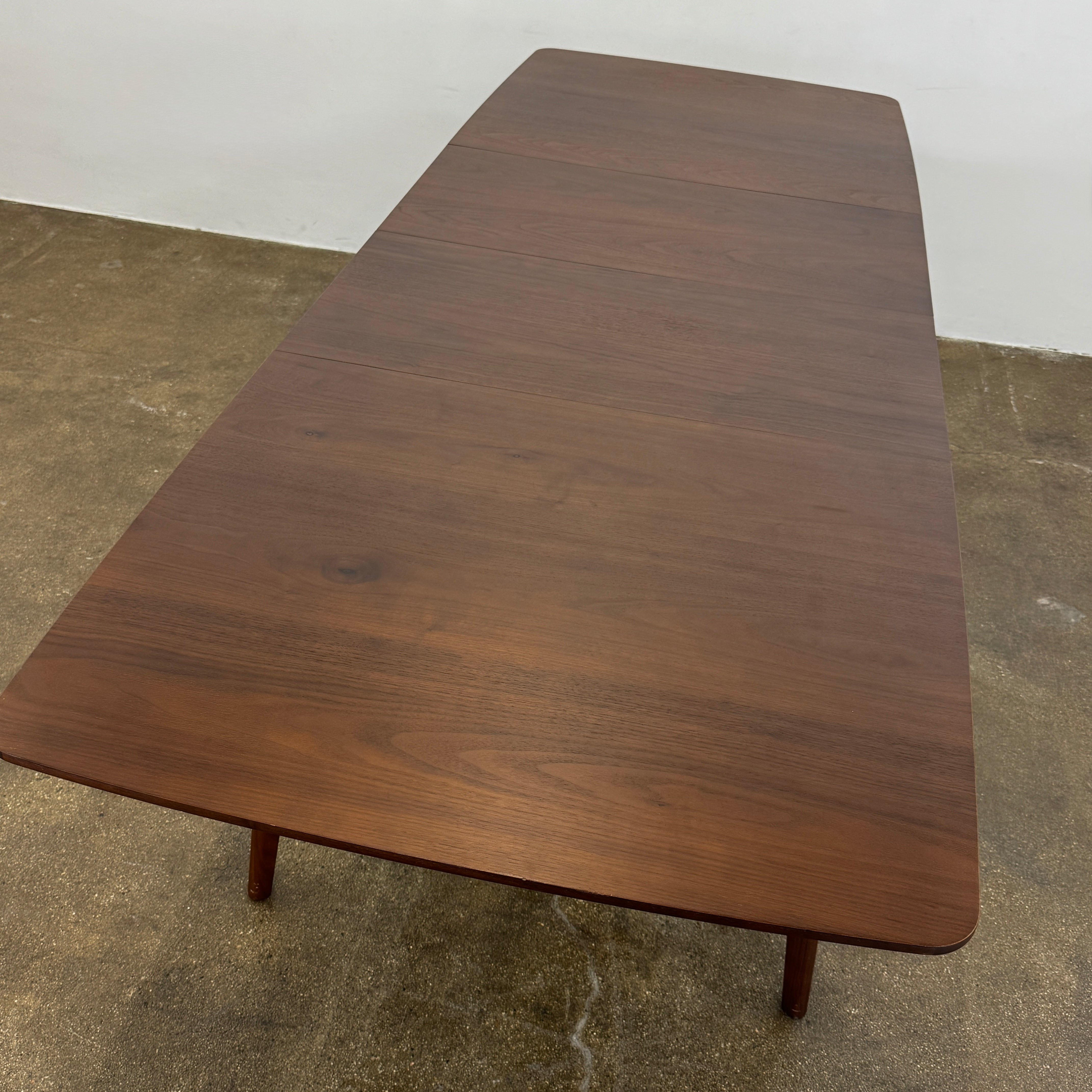 The Case Design Dulwich Extension Table by Case is an elegant rectangular walnut dining table with four legs and a smooth, flat surface, viewed from the front against a plain white background—ideal for modern dining spaces.