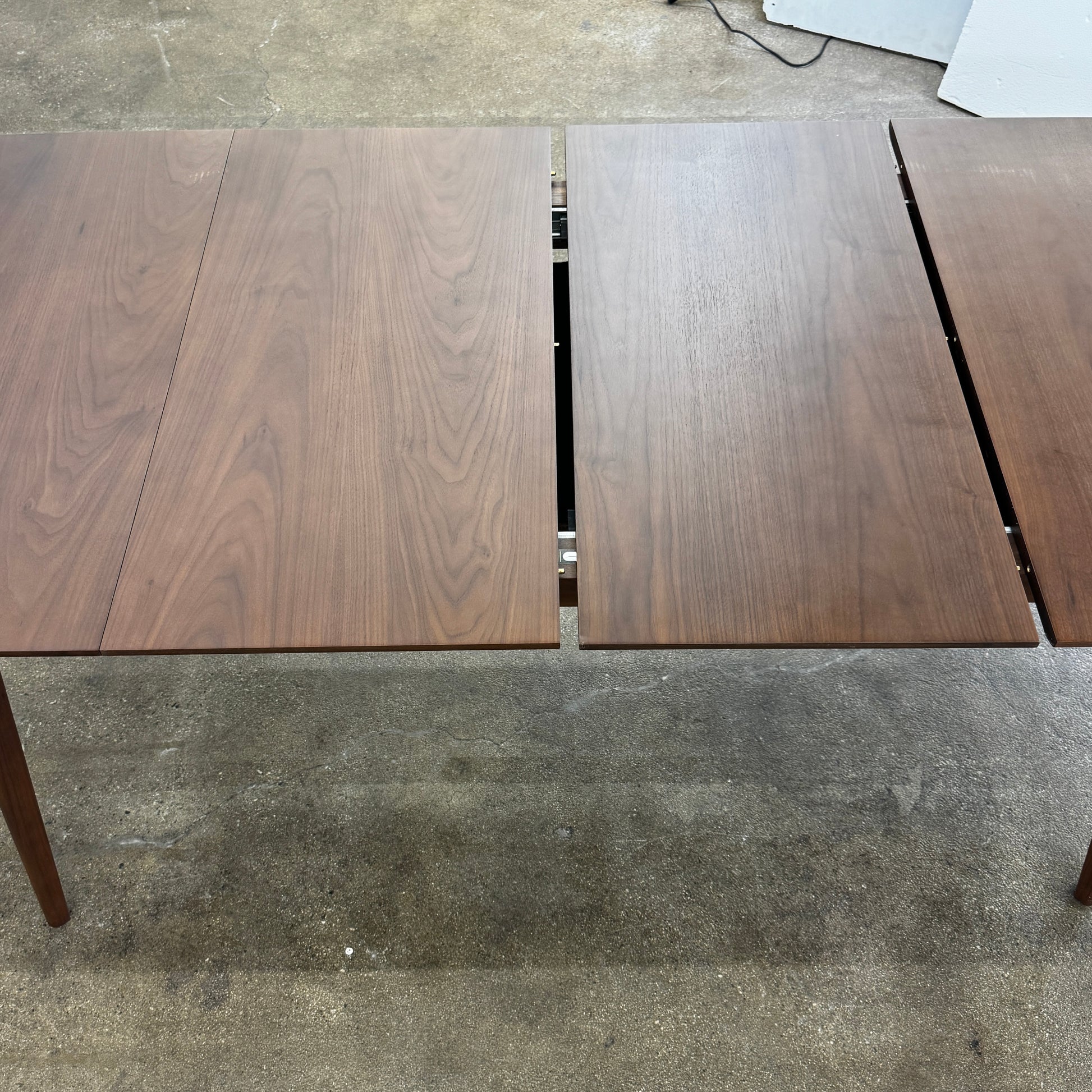 The Case Design Dulwich Extension Table by Case is an elegant rectangular walnut dining table with four legs and a smooth, flat surface, viewed from the front against a plain white background—ideal for modern dining spaces.