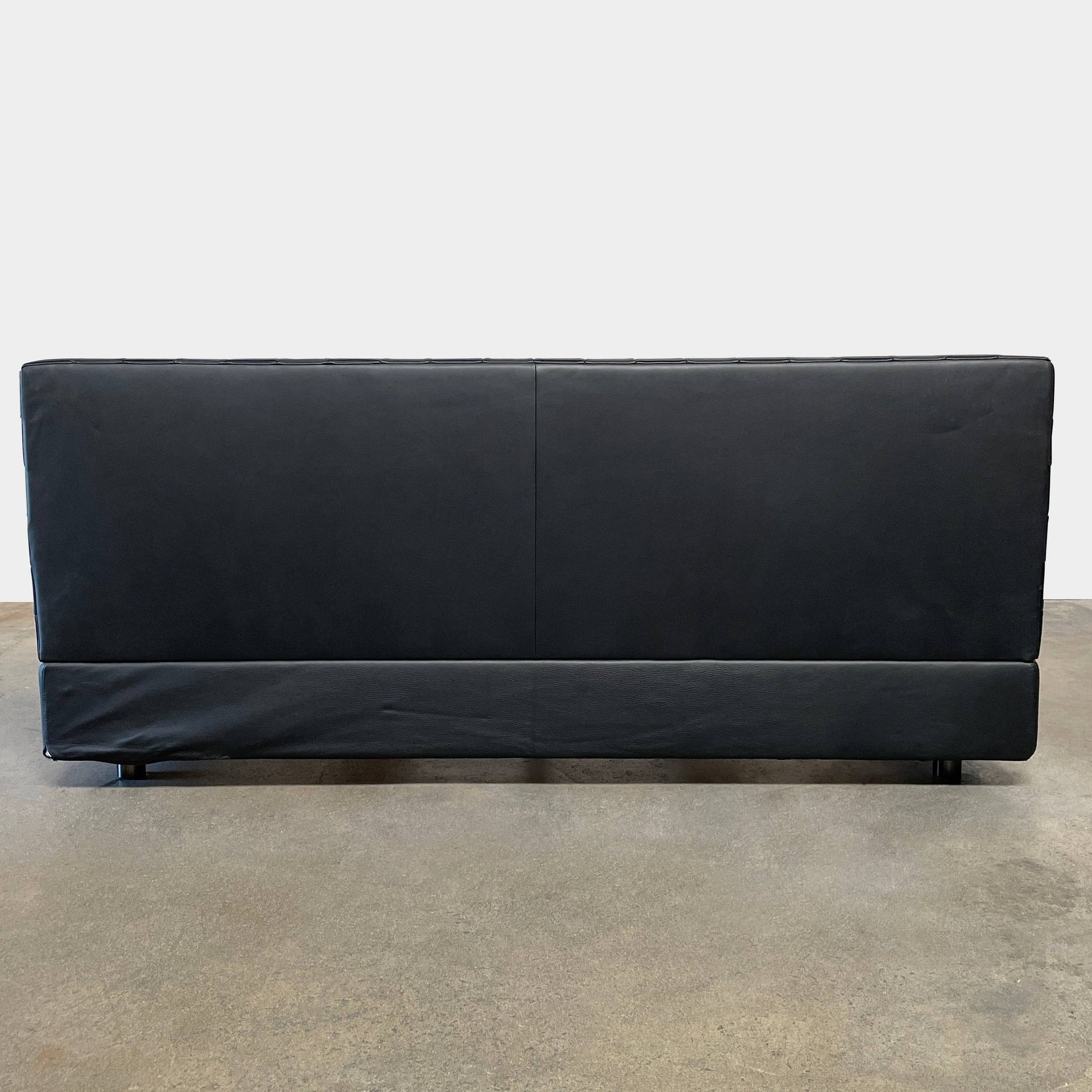 A Minotti Bartlett Cal King Bed with a wooden slatted base.