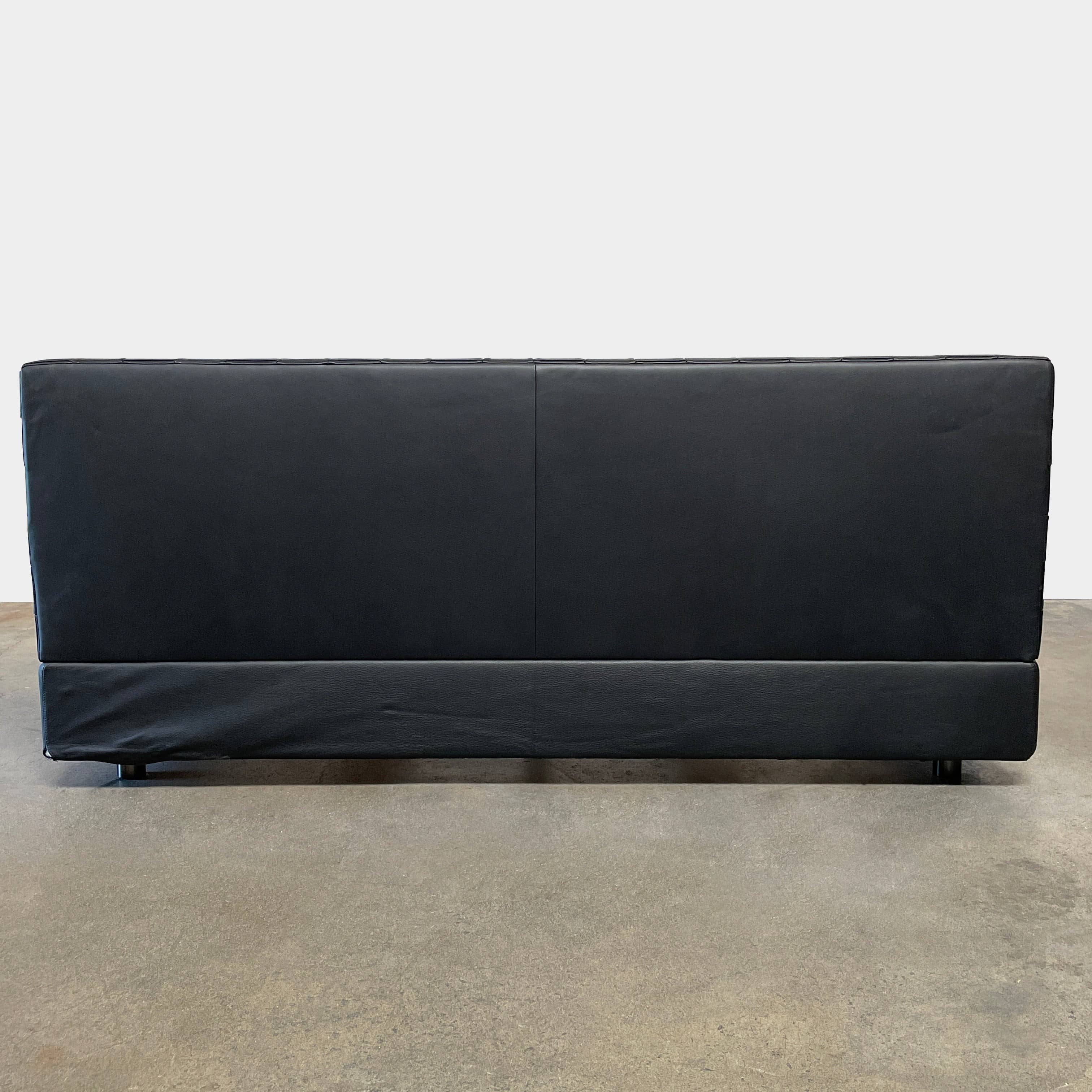 A Minotti Bartlett Cal King Bed with a wooden slatted base.