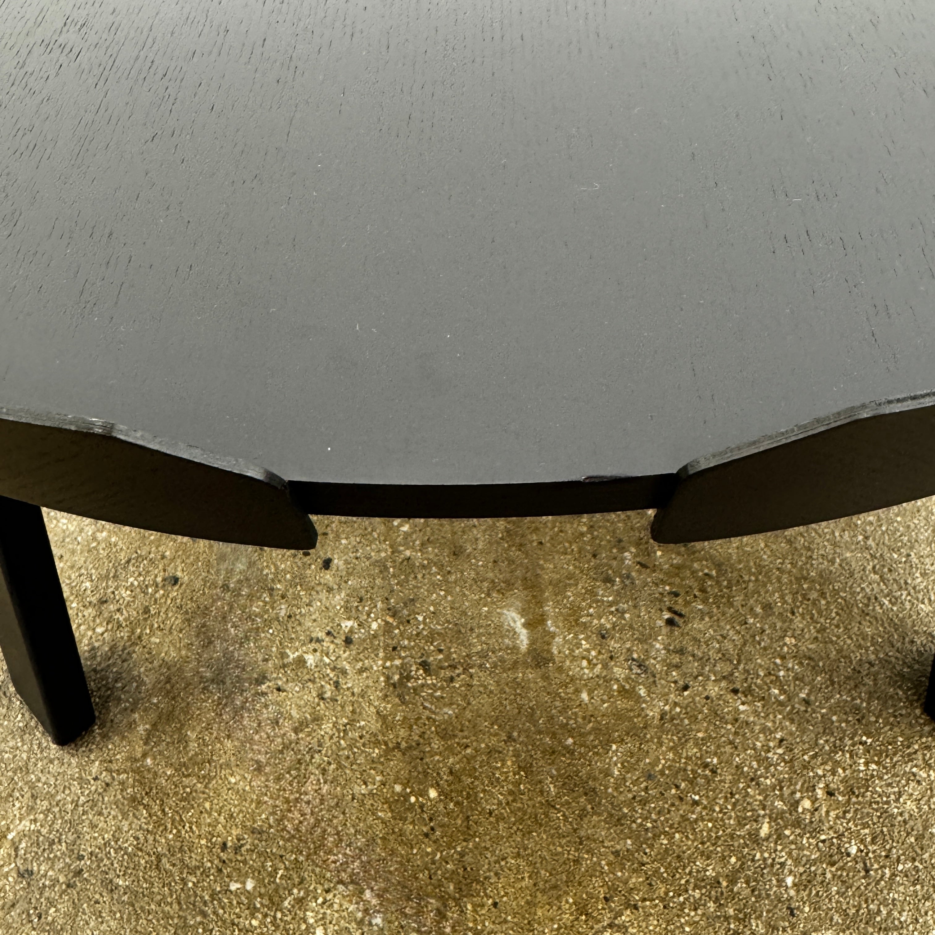 The Muuto Around Coffee Table by Muuto is a round, black wooden table with three legs and Scandinavian design, displayed against a plain light background.