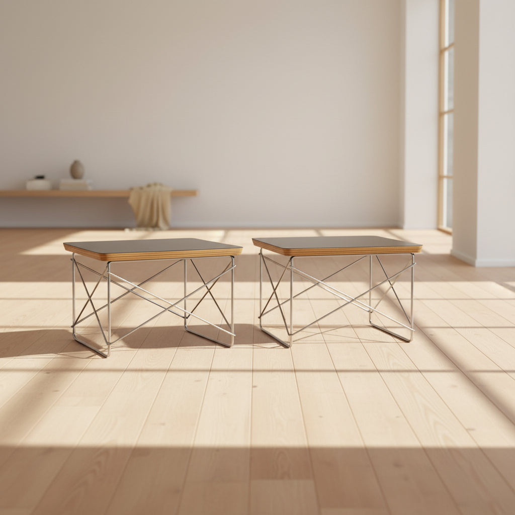 Two Herman Miller Eames Wire Base Low Tables are set side by side on a light wood floor in a bright, minimalist room, showcasing the iconic design and craftsmanship of Herman Miller.