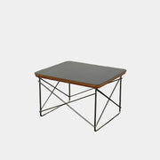 Two Herman Miller Eames Wire Base Low Tables are set side by side on a light wood floor in a bright, minimalist room, showcasing the iconic design and craftsmanship of Herman Miller.