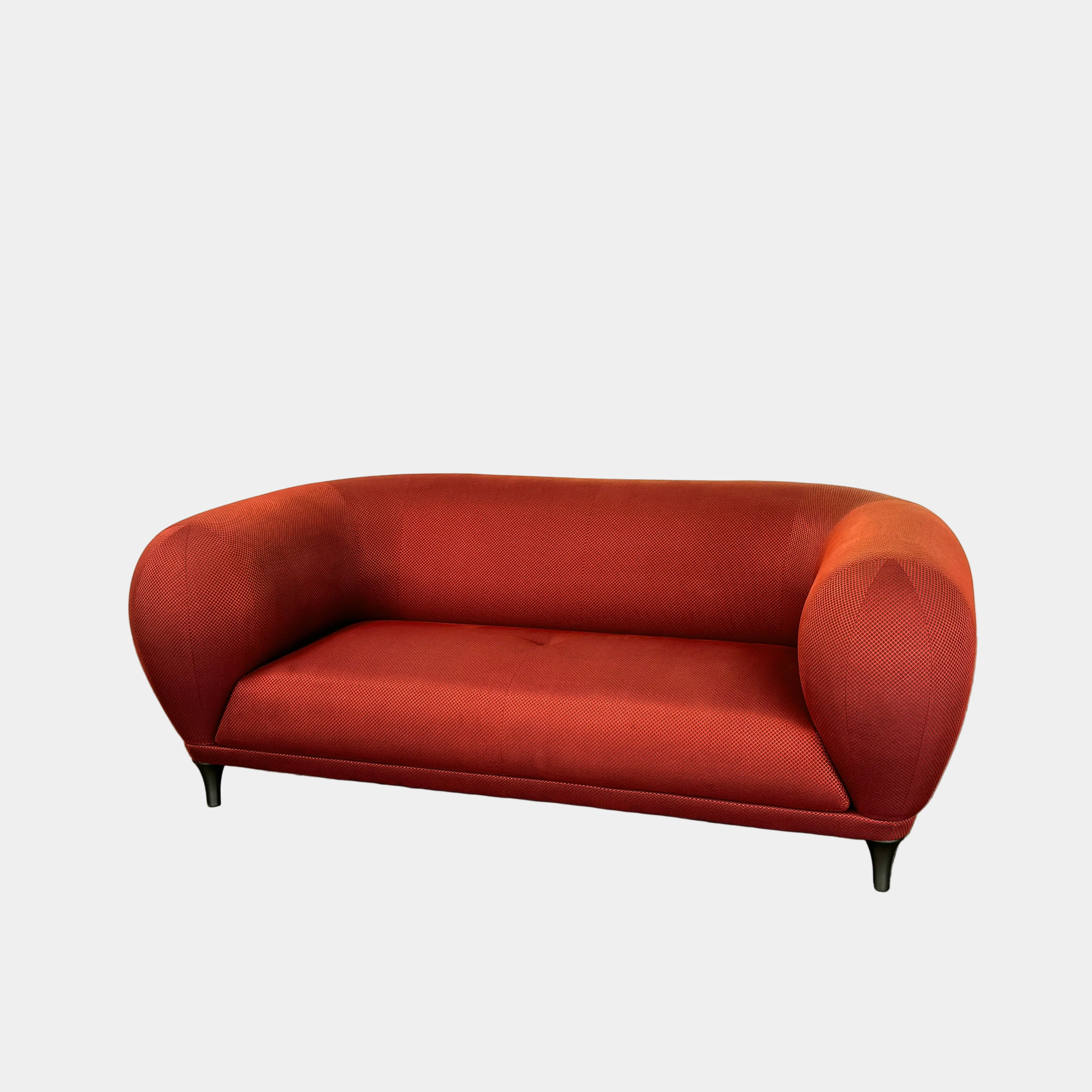 The Roche Bobois Montgolfiere Love seat is a modern, red 2-seat sofa with curved arms and dark wooden legs by Roche Bobois, shown against a plain background.