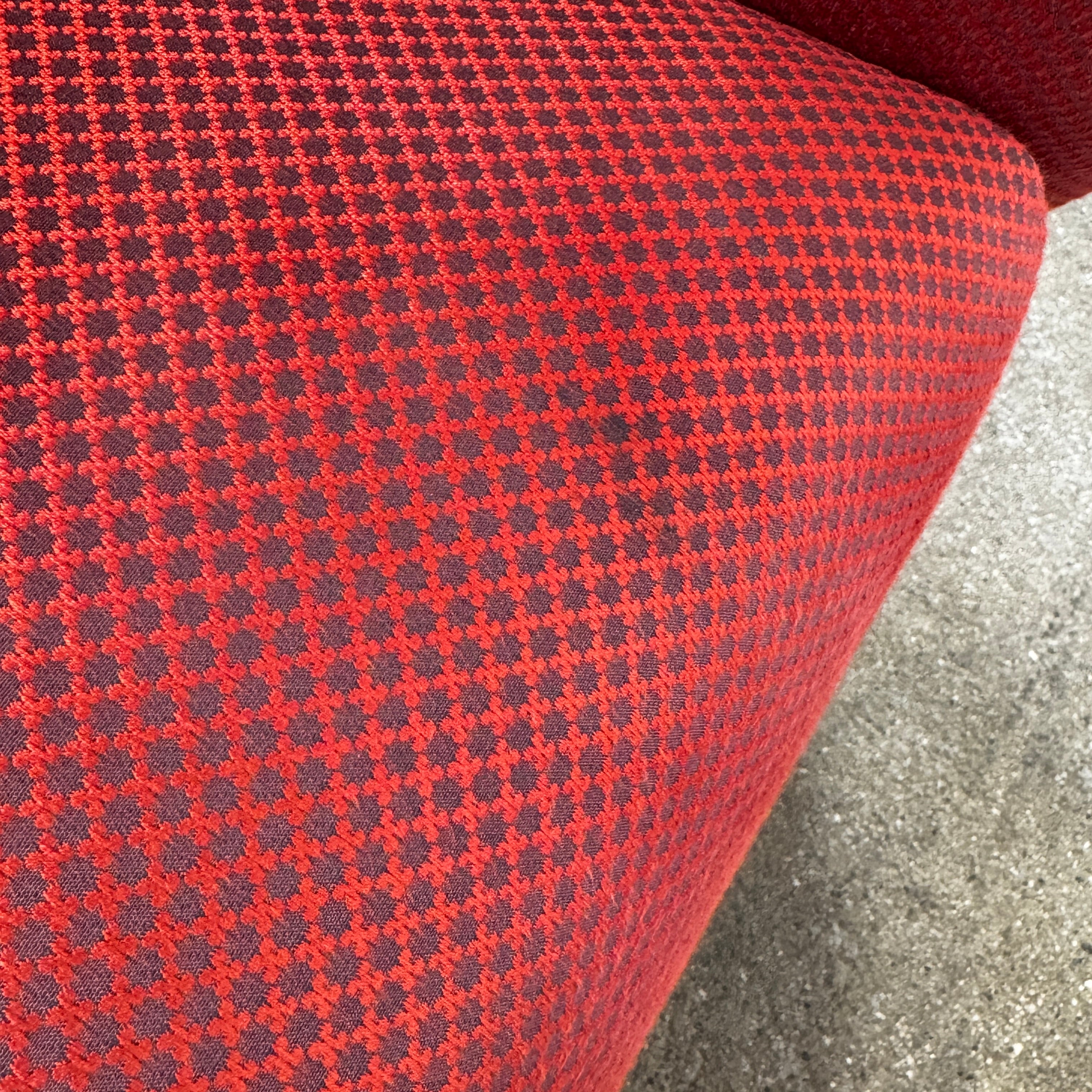 The Roche Bobois Montgolfiere Love seat is a modern, red 2-seat sofa with curved arms and dark wooden legs by Roche Bobois, shown against a plain background.