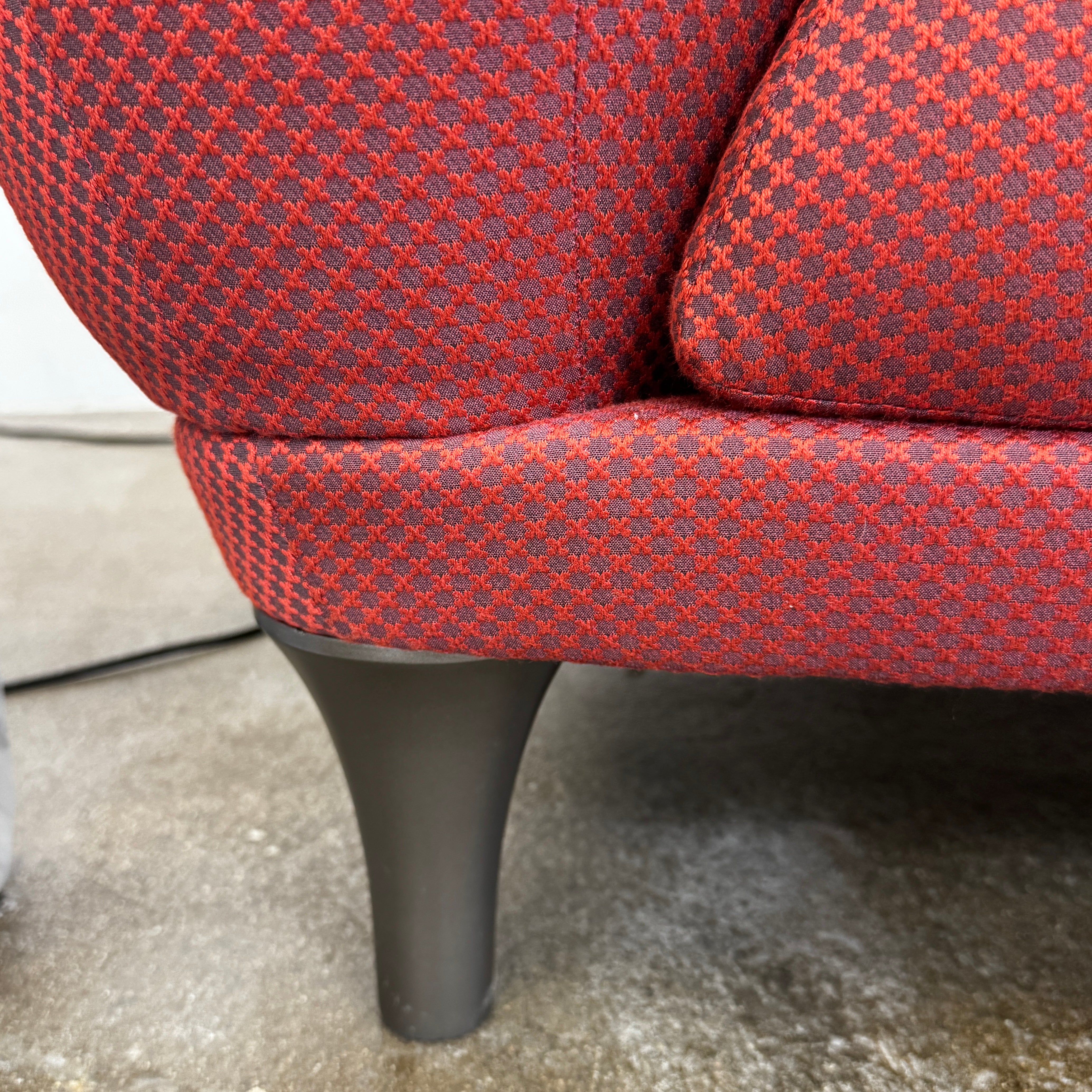 The Roche Bobois Montgolfiere Love seat is a modern, red 2-seat sofa with curved arms and dark wooden legs by Roche Bobois, shown against a plain background.