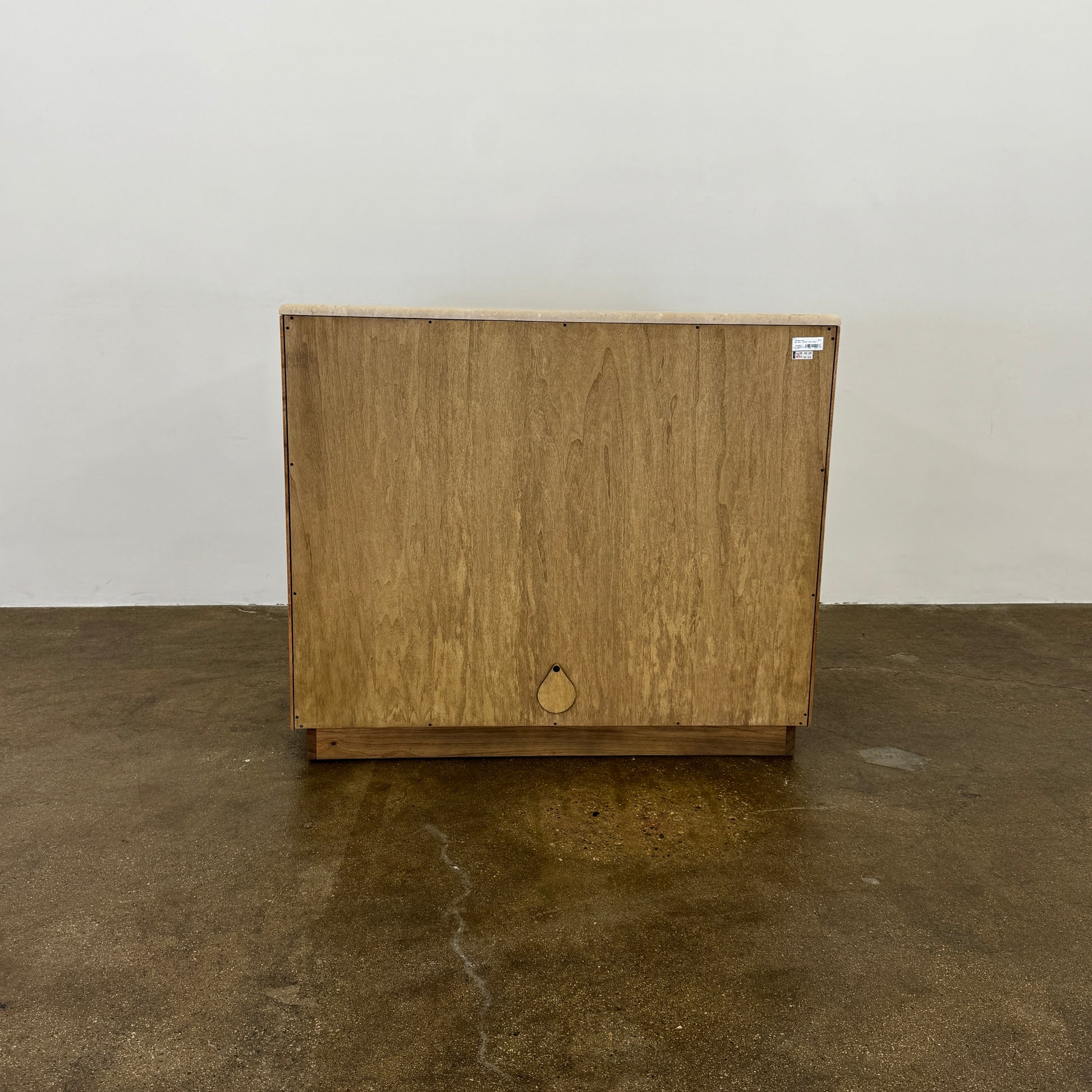 The Boa Small Cabinet by Fourhands features two doors, a gently curved front, light natural wood finish, and round handles, bringing contemporary style to any space.