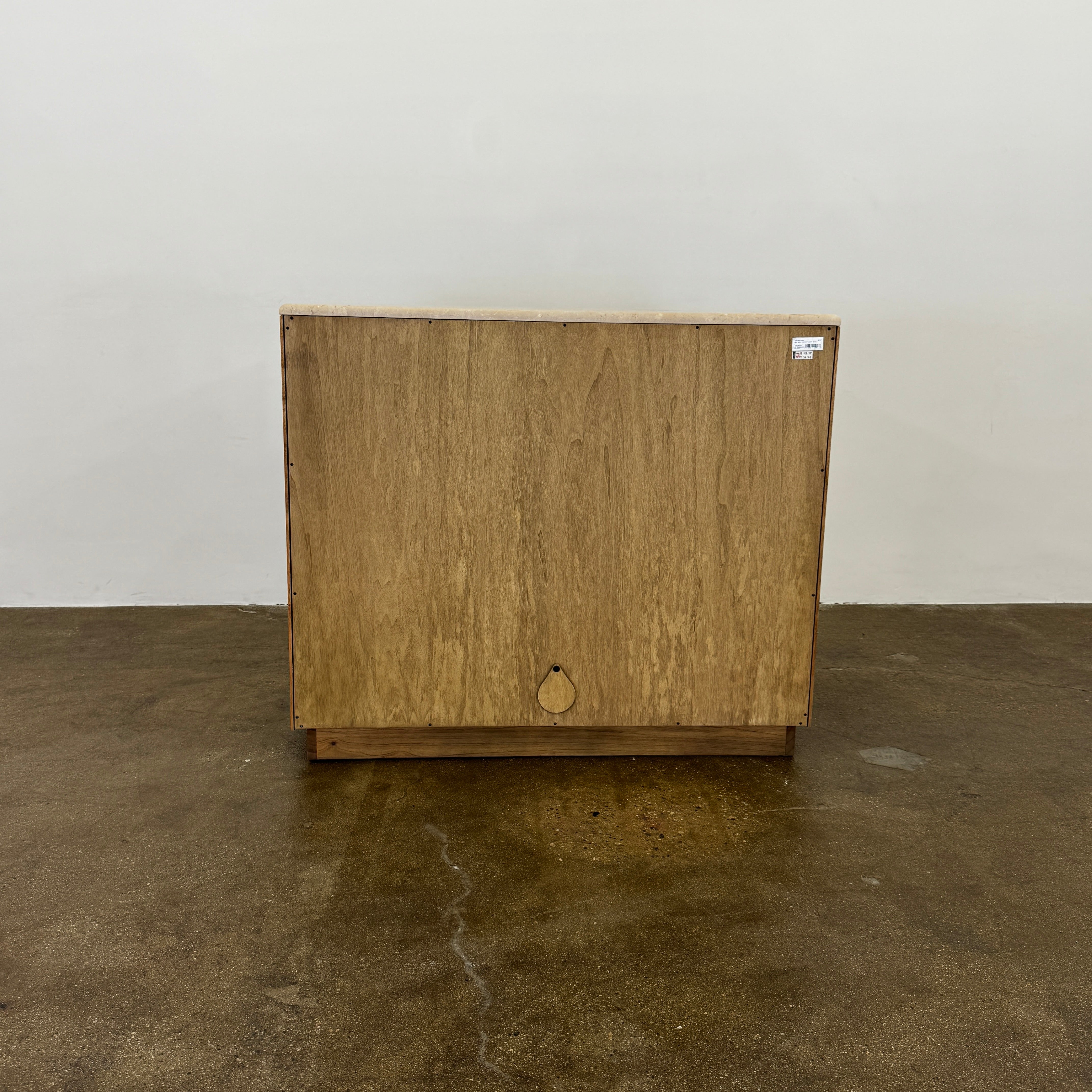 The Boa Small Cabinet by Fourhands features two doors, a gently curved front, light natural wood finish, and round handles, bringing contemporary style to any space.