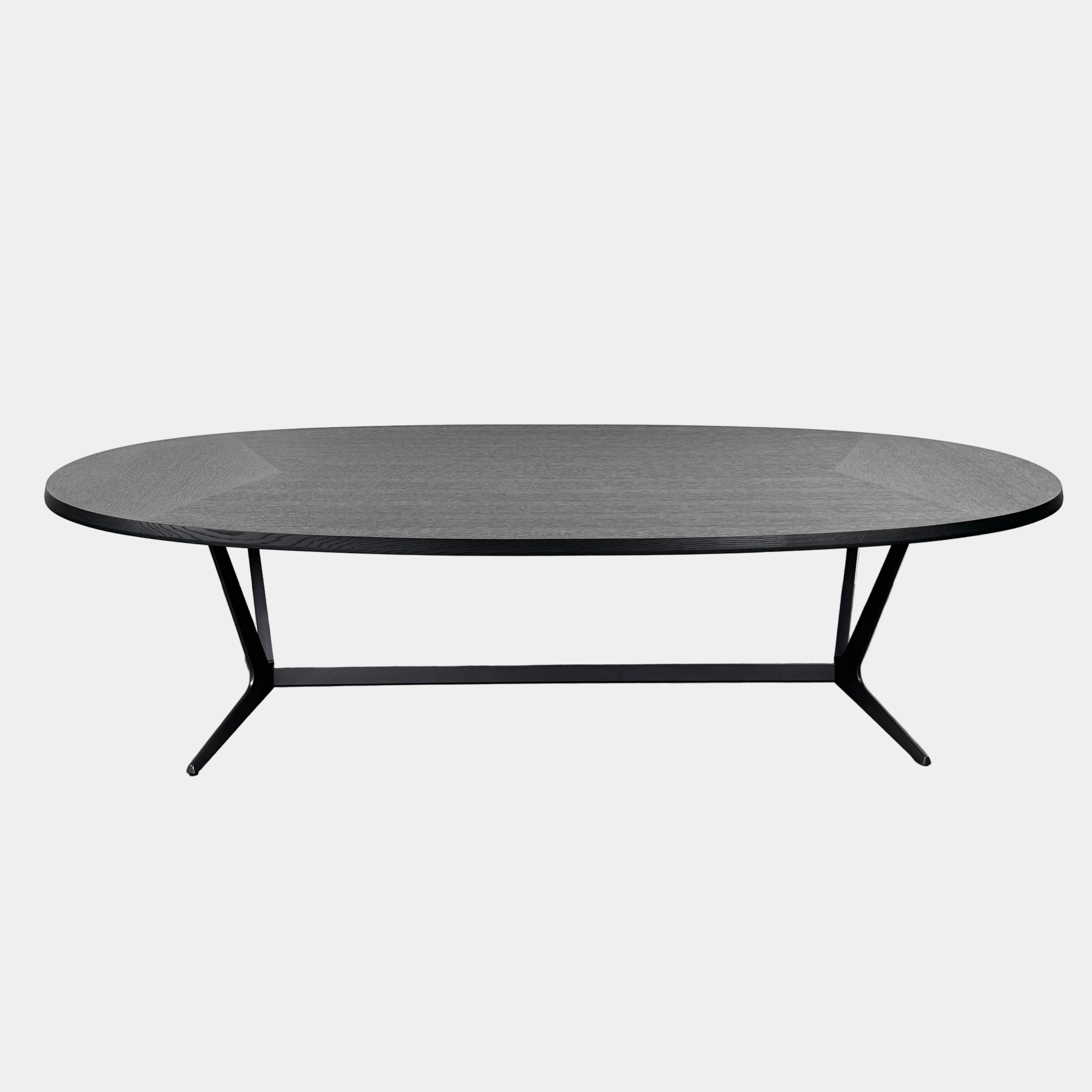 A spacious Maxalto Astrum Dining Table by Maxalto with black oak finish and bronze nickel base is paired with eight evenly arranged dark brown chairs in a minimalist setting.