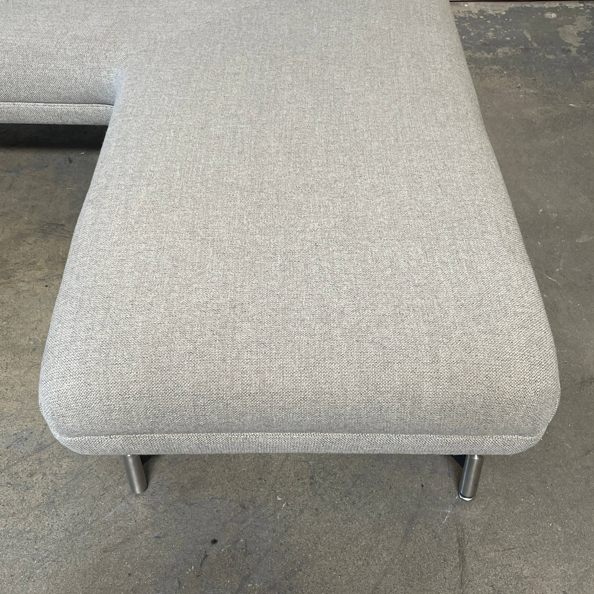 A Kagan Swan L-Shaped Sofa with legs on a white background.