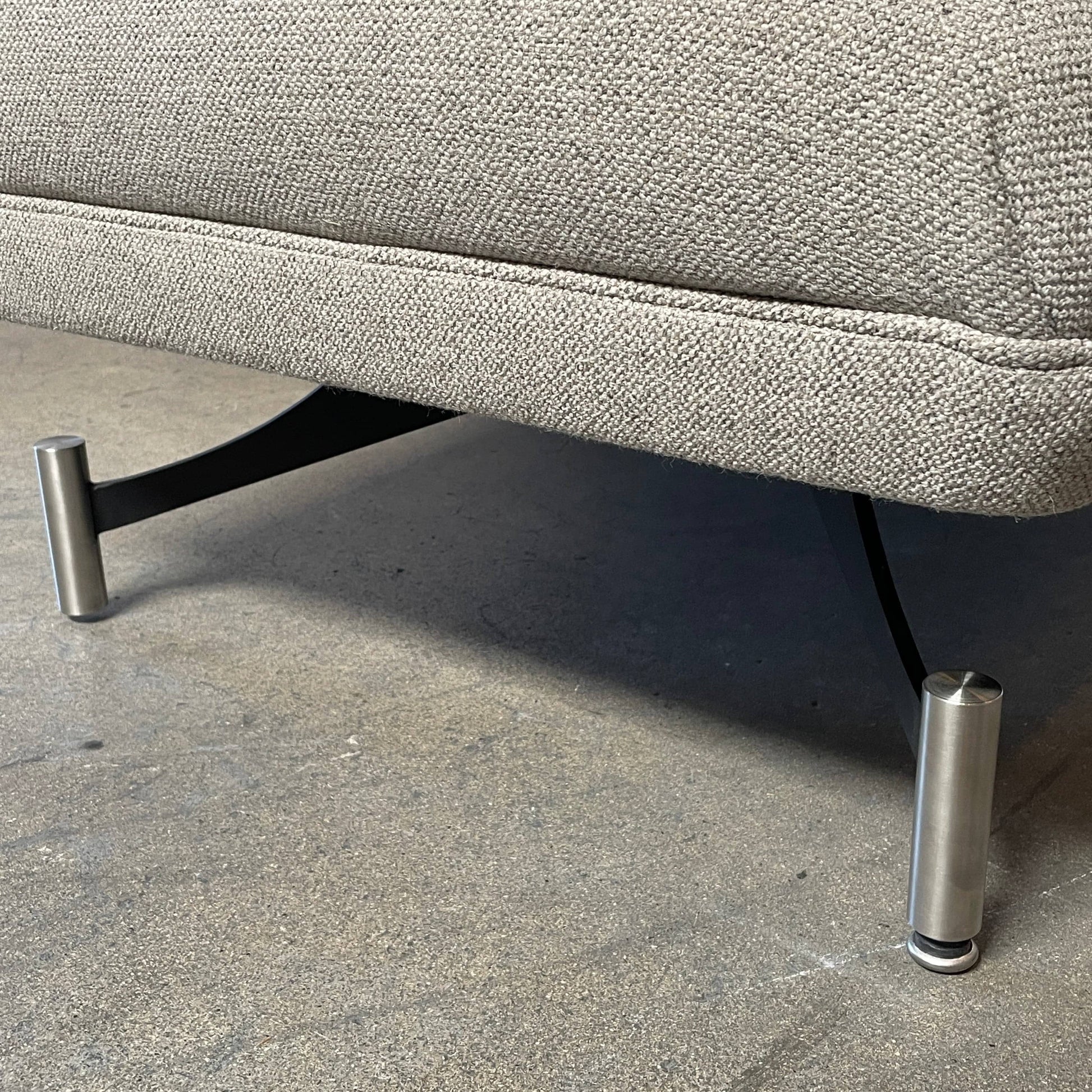 A Kagan Swan L-Shaped Sofa with legs on a white background.