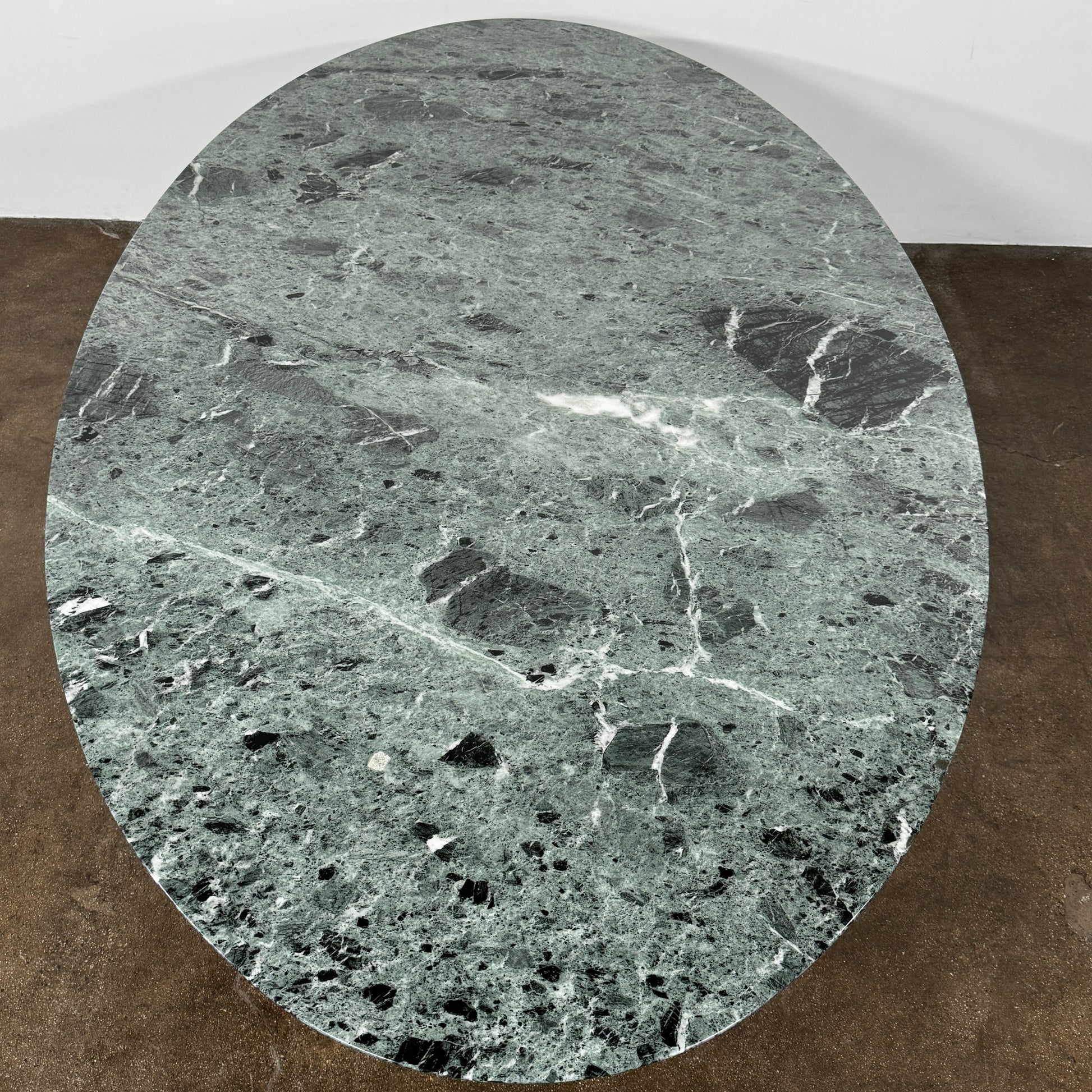 The Knoll Oval Verde Alpi Marble Saarinen Table features a gray marble top and a black pedestal base, inspired by the classic design, set against a plain white background.