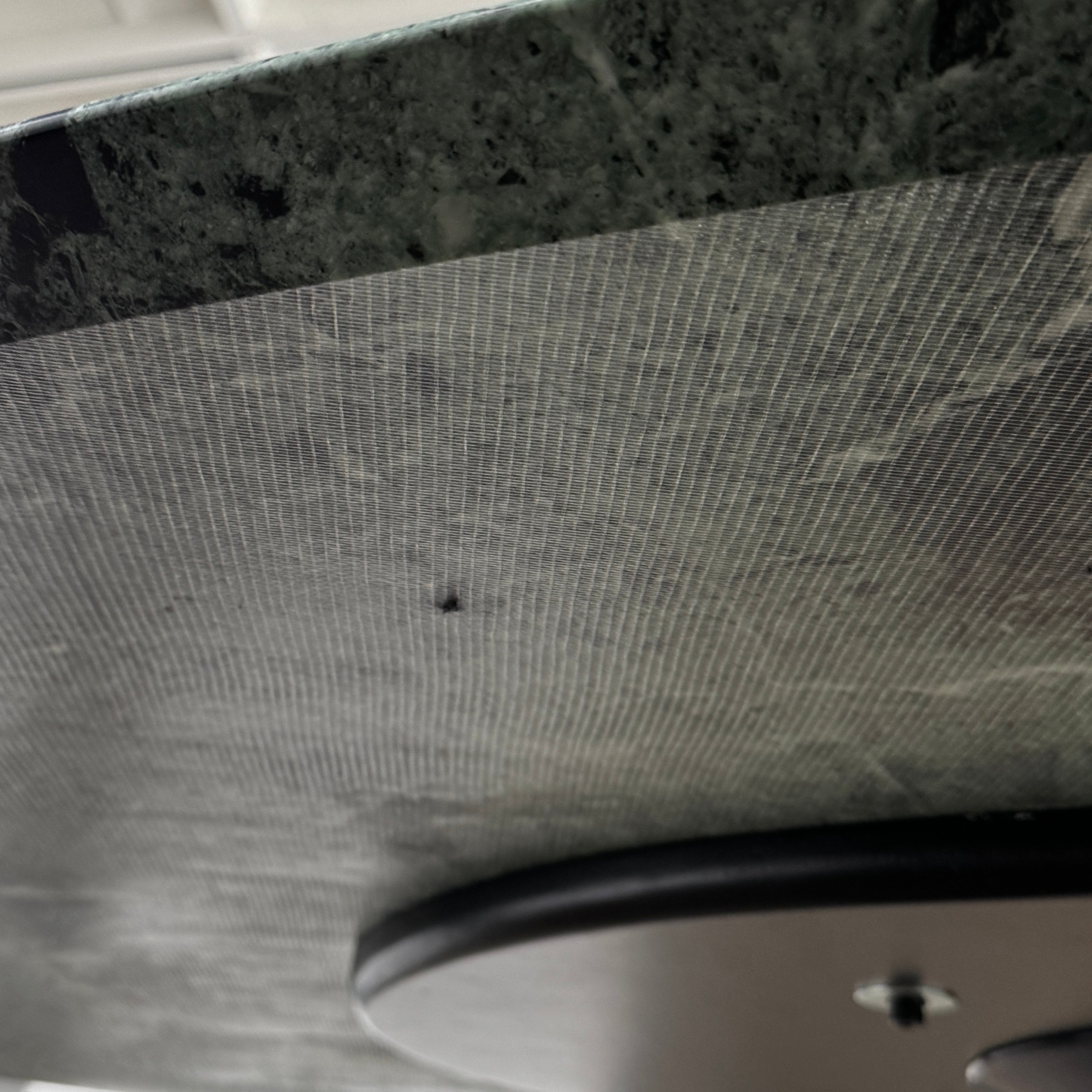 The Knoll Oval Verde Alpi Marble Saarinen Table features a gray marble top and a black pedestal base, inspired by the classic design, set against a plain white background.