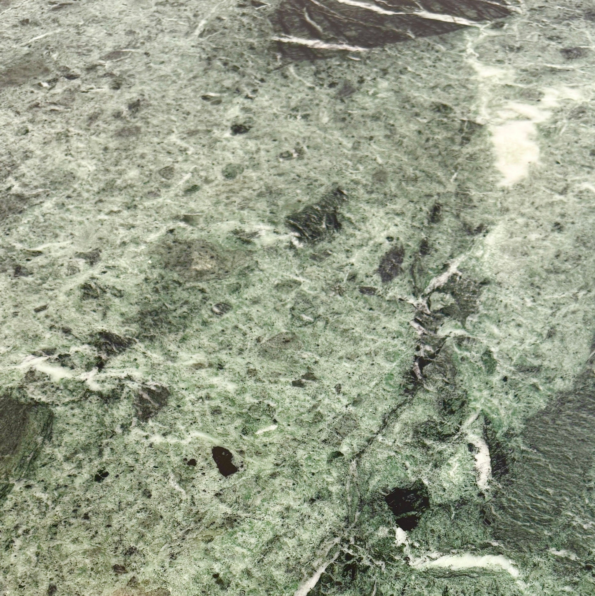 The Knoll Oval Verde Alpi Marble Saarinen Table features a gray marble top and a black pedestal base, inspired by the classic design, set against a plain white background.