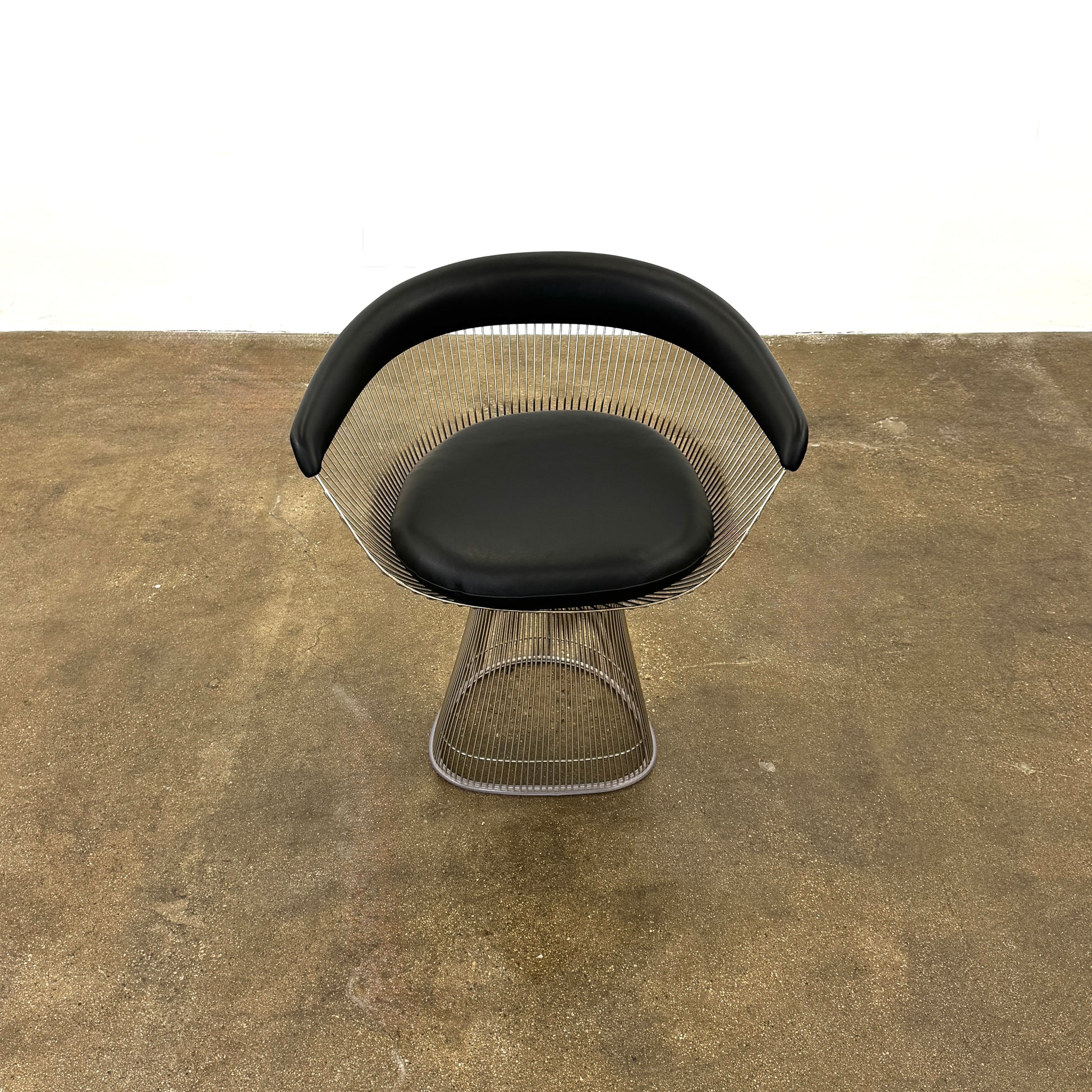 A set of six Knoll Platner Armchairs by Knoll, featuring black seats and backs with metal wire bases, inspired by modernist design, arranged in two rows against a plain white background.