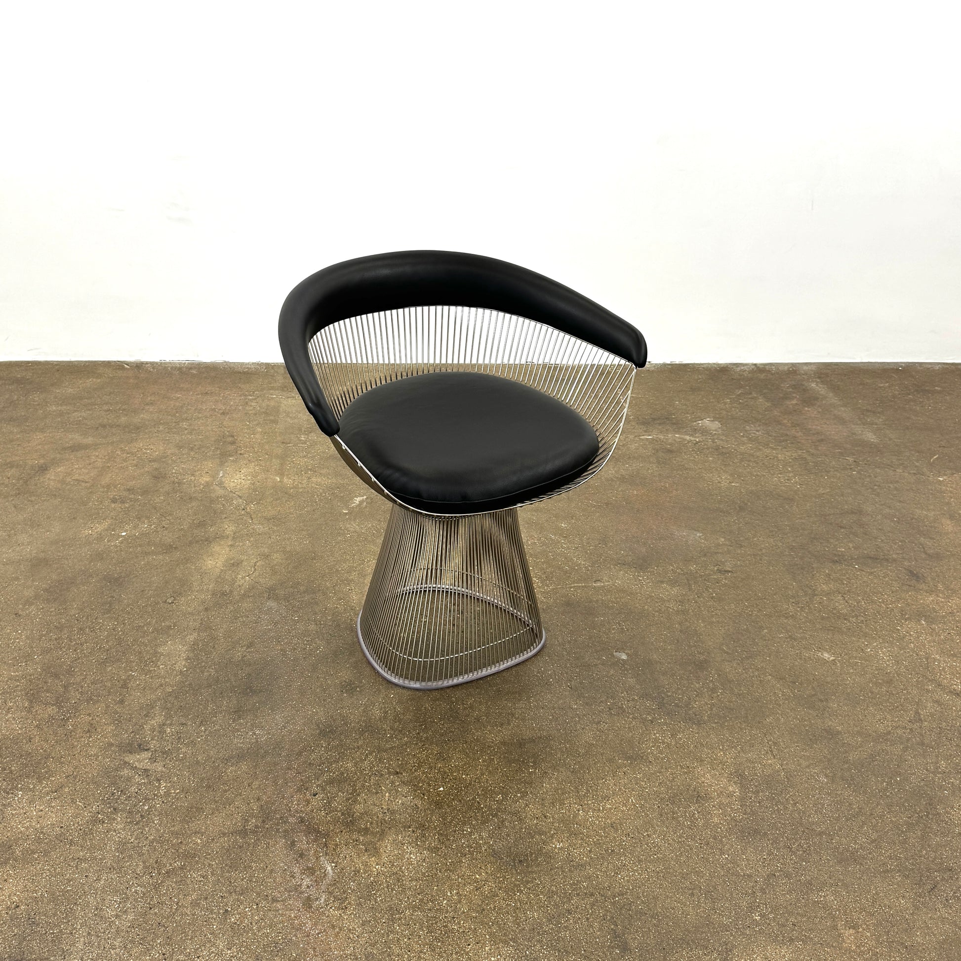 A set of six Knoll Platner Armchairs by Knoll, featuring black seats and backs with metal wire bases, inspired by modernist design, arranged in two rows against a plain white background.