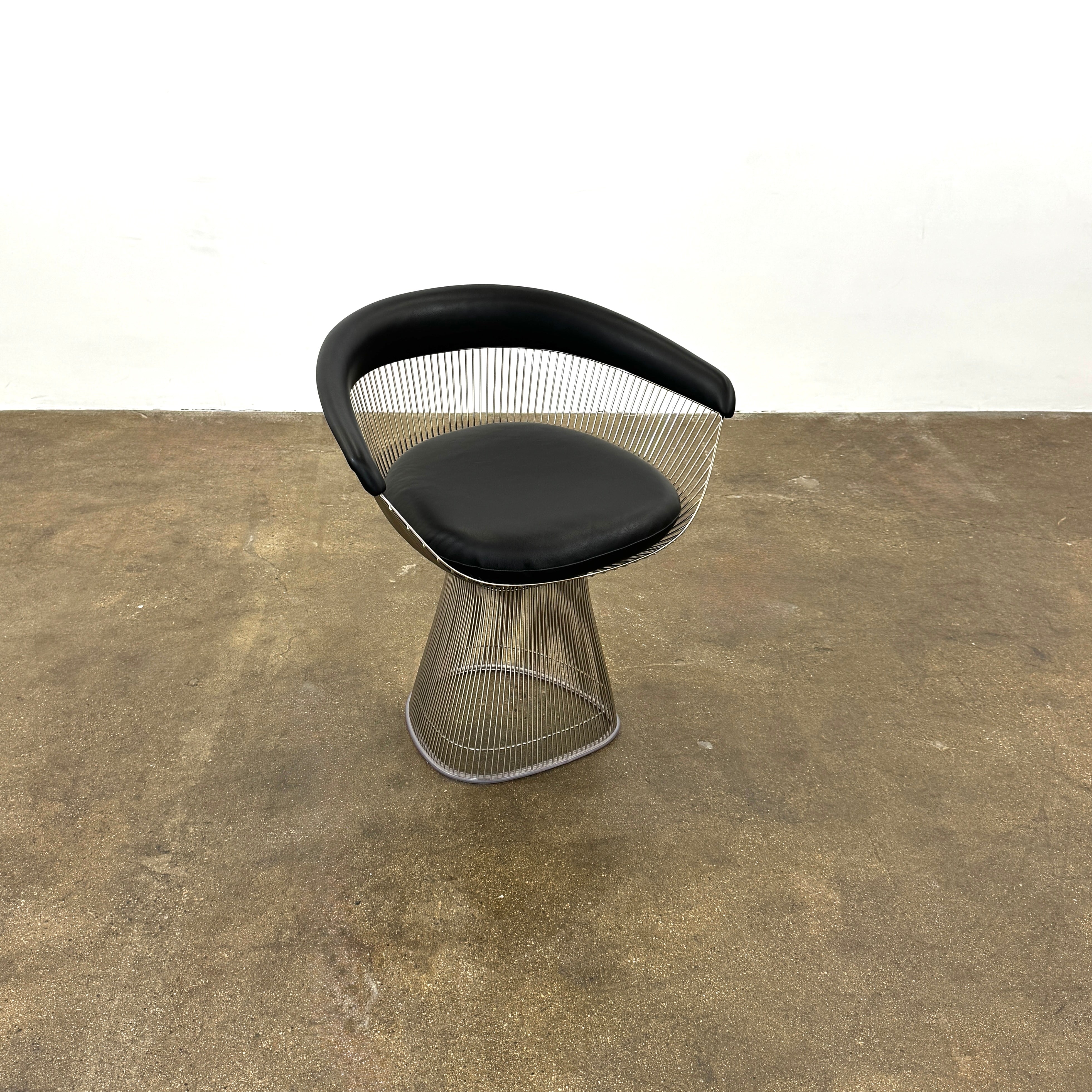 A set of six Knoll Platner Armchairs by Knoll, featuring black seats and backs with metal wire bases, inspired by modernist design, arranged in two rows against a plain white background.