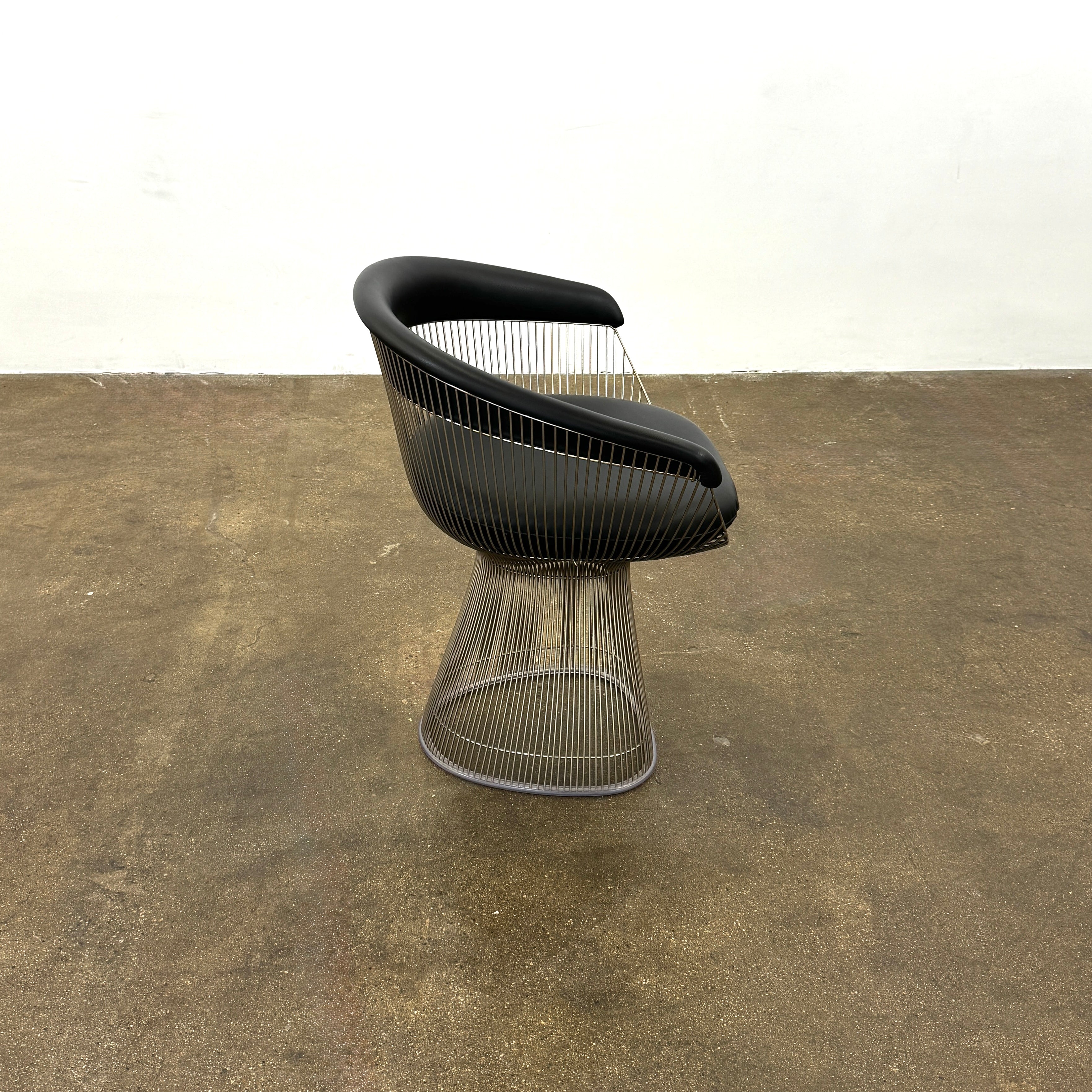 A set of six Knoll Platner Armchairs by Knoll, featuring black seats and backs with metal wire bases, inspired by modernist design, arranged in two rows against a plain white background.
