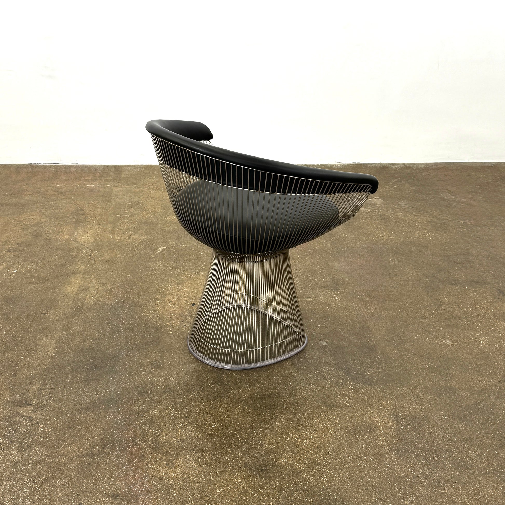 A set of six Knoll Platner Armchairs by Knoll, featuring black seats and backs with metal wire bases, inspired by modernist design, arranged in two rows against a plain white background.