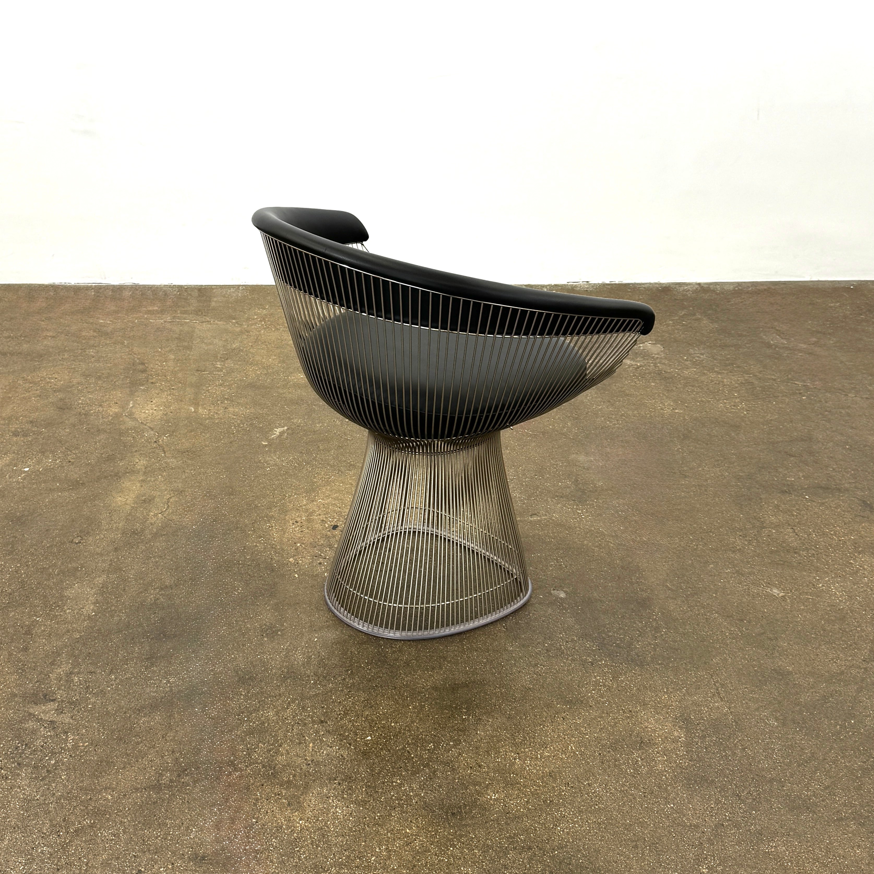 A set of six Knoll Platner Armchairs by Knoll, featuring black seats and backs with metal wire bases, inspired by modernist design, arranged in two rows against a plain white background.