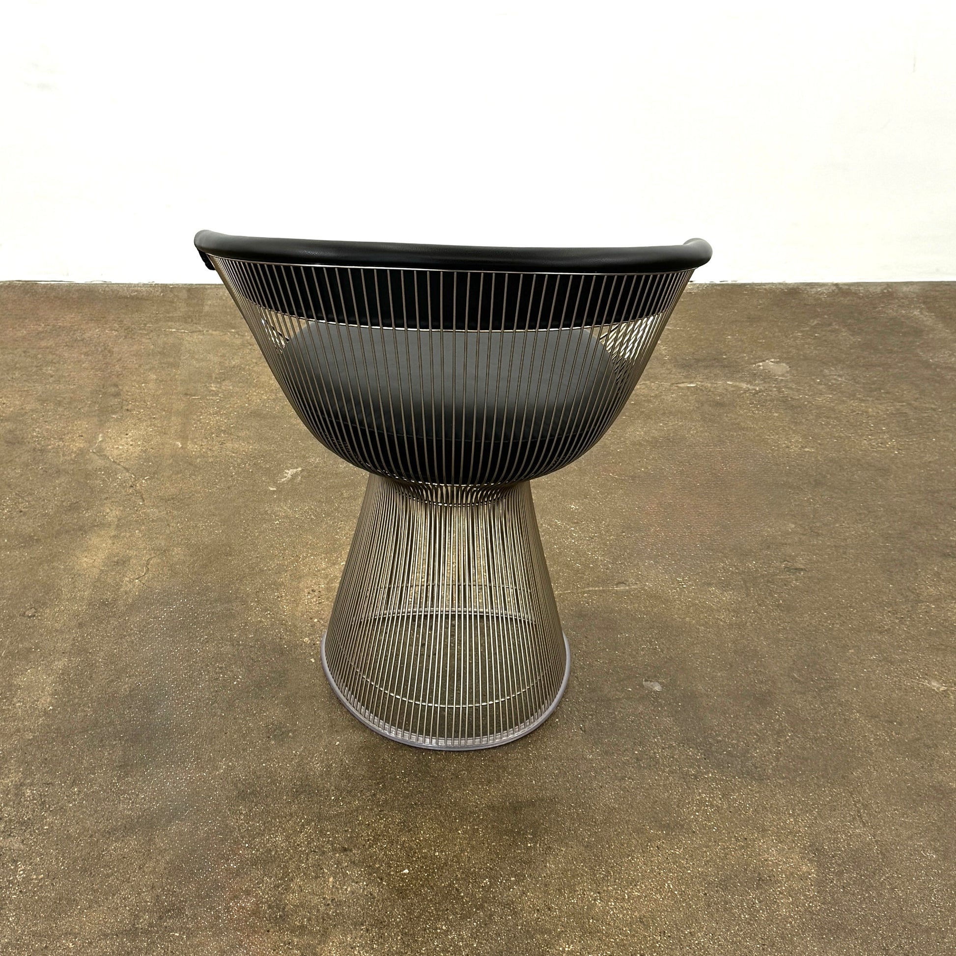A set of six Knoll Platner Armchairs by Knoll, featuring black seats and backs with metal wire bases, inspired by modernist design, arranged in two rows against a plain white background.