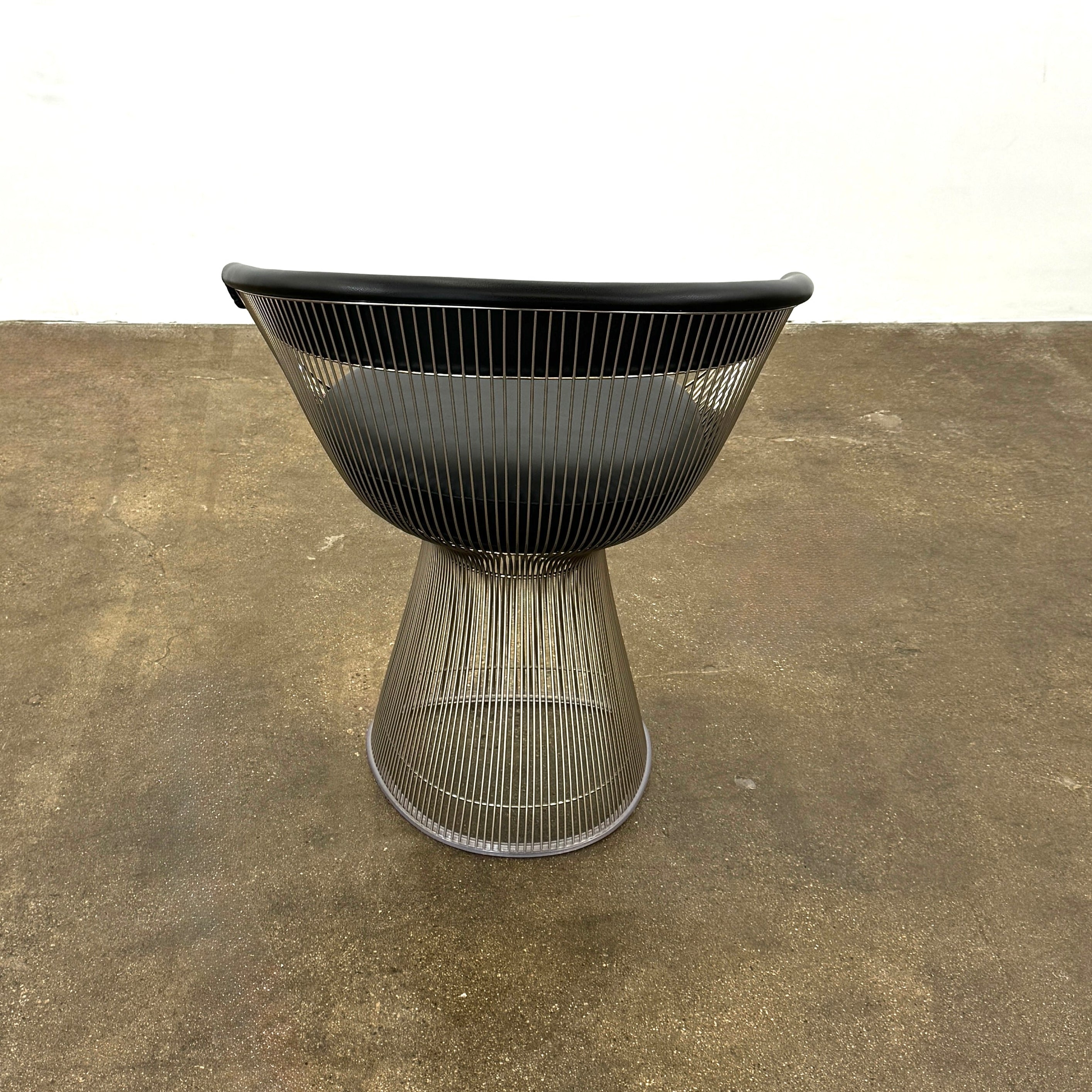 A set of six Knoll Platner Armchairs by Knoll, featuring black seats and backs with metal wire bases, inspired by modernist design, arranged in two rows against a plain white background.