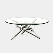 The Cassina "Tensegrity" 713 Cocktail Table features a round glass top and a geometric chrome metal base with tension cables, displayed on a plain white background.