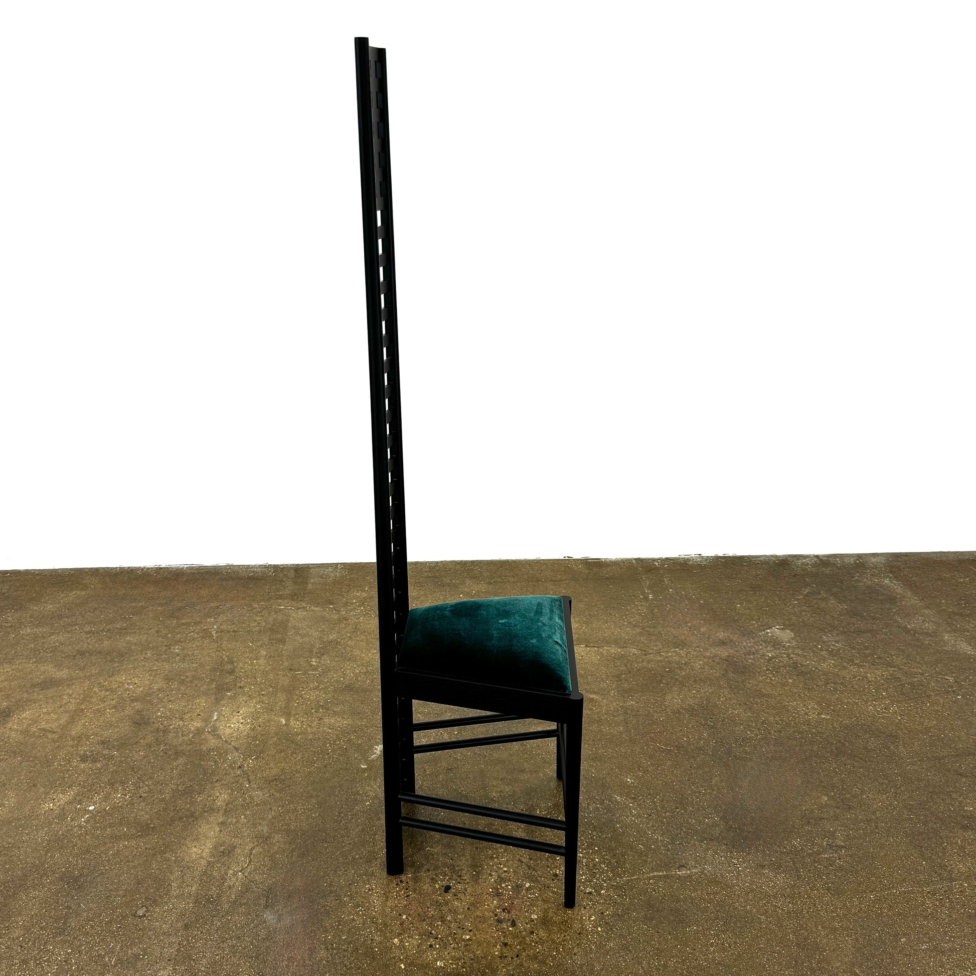 A pair of Cassina 292 Hill House Chairs by Charles R. Mackintosh, with black slatted frames—one featuring a burgundy seat cushion, the other dark green—showcasing Cassina's modernist design against a plain white background.