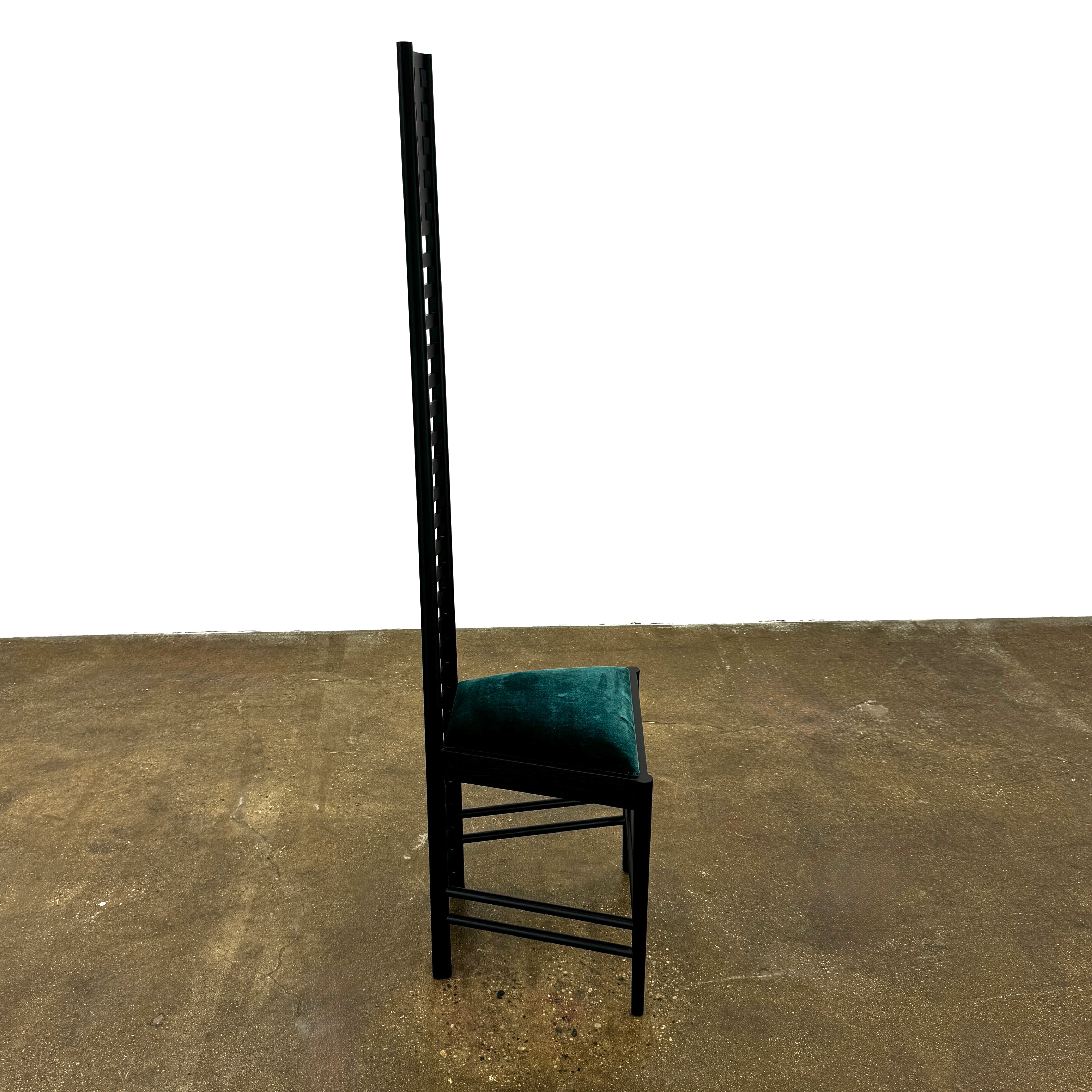 A pair of Cassina 292 Hill House Chairs by Charles R. Mackintosh, with black slatted frames—one featuring a burgundy seat cushion, the other dark green—showcasing Cassina's modernist design against a plain white background.