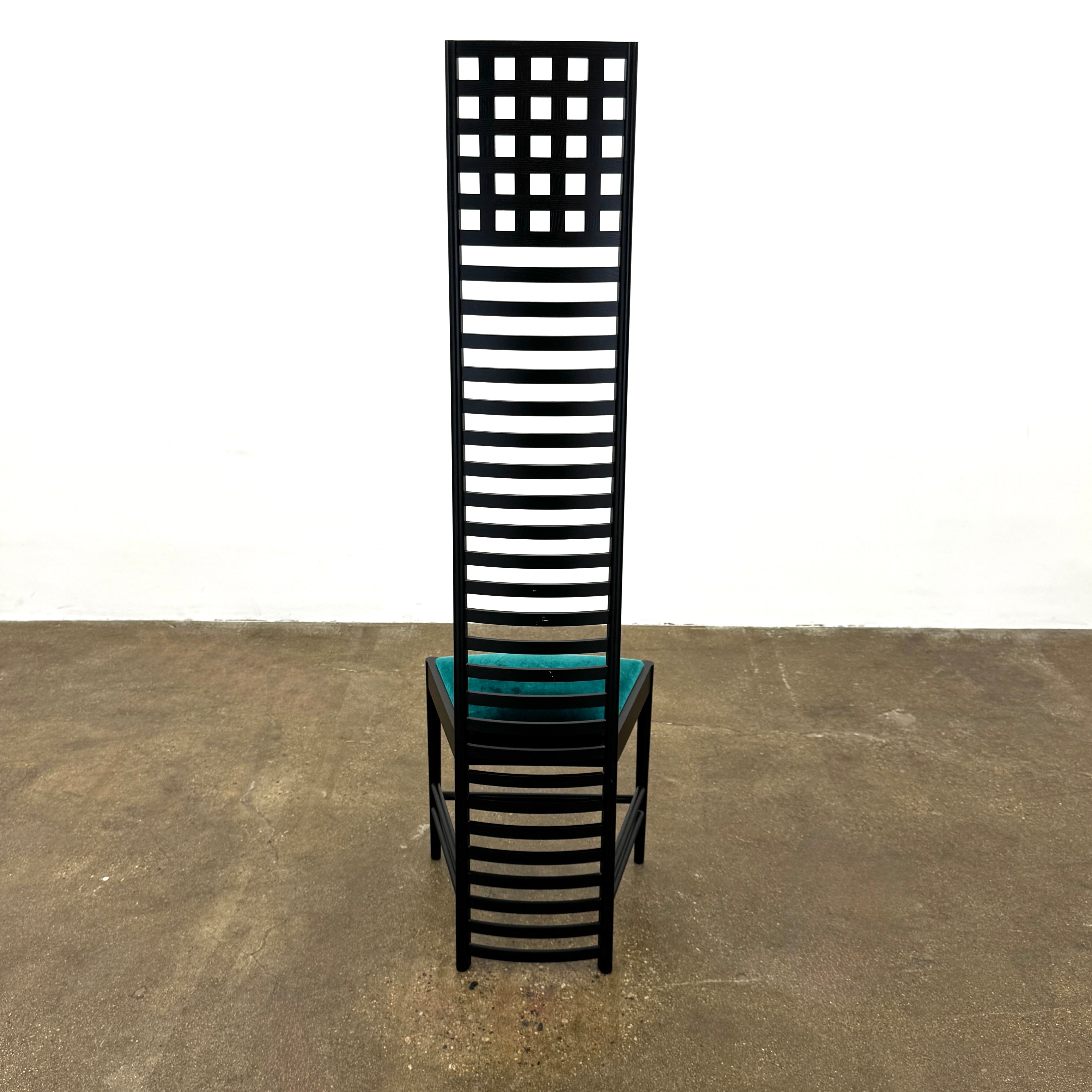 A pair of Cassina 292 Hill House Chairs by Charles R. Mackintosh, with black slatted frames—one featuring a burgundy seat cushion, the other dark green—showcasing Cassina's modernist design against a plain white background.