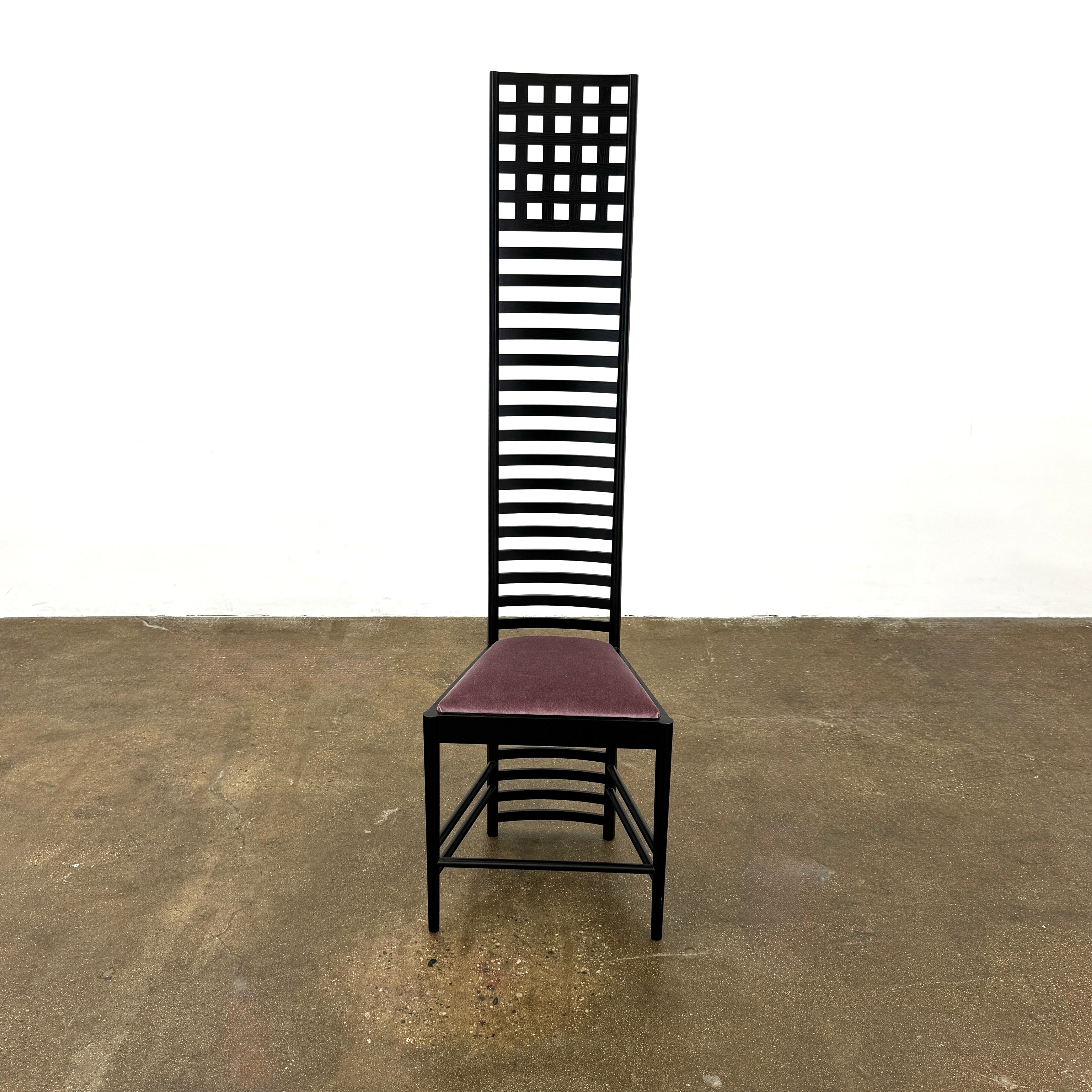 A pair of Cassina 292 Hill House Chairs by Charles R. Mackintosh, with black slatted frames—one featuring a burgundy seat cushion, the other dark green—showcasing Cassina's modernist design against a plain white background.