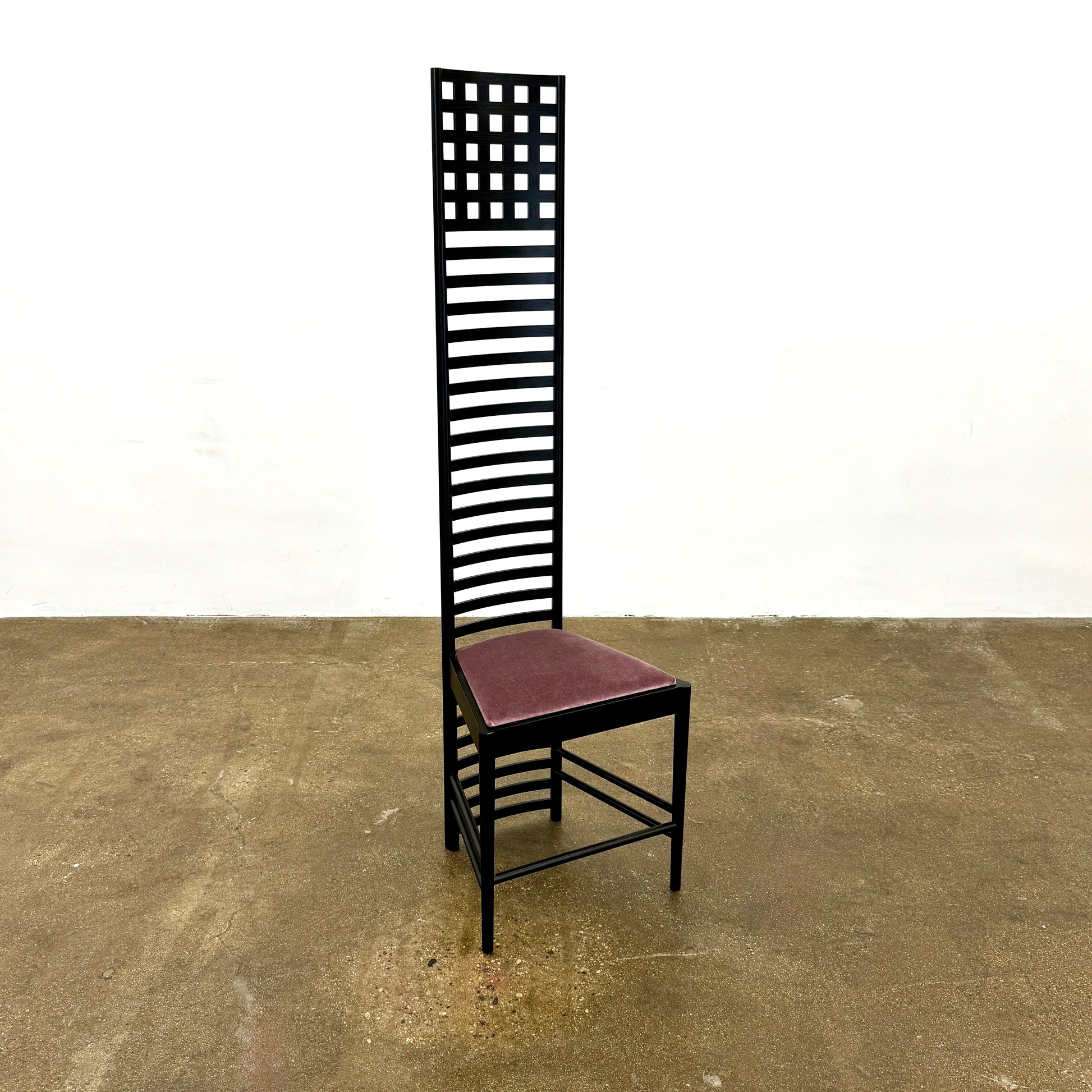 A pair of Cassina 292 Hill House Chairs by Charles R. Mackintosh, with black slatted frames—one featuring a burgundy seat cushion, the other dark green—showcasing Cassina's modernist design against a plain white background.