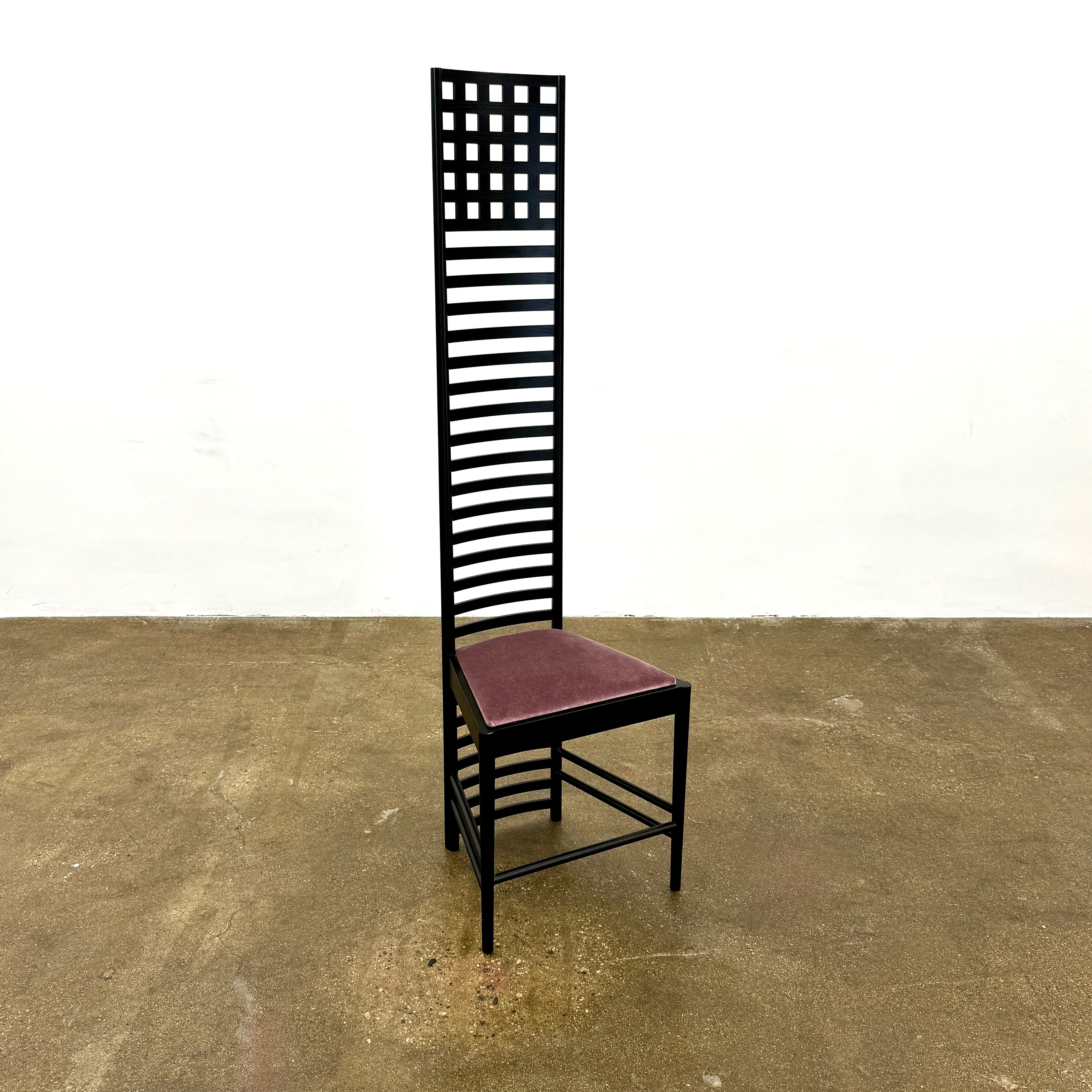 A pair of Cassina 292 Hill House Chairs by Charles R. Mackintosh, with black slatted frames—one featuring a burgundy seat cushion, the other dark green—showcasing Cassina's modernist design against a plain white background.