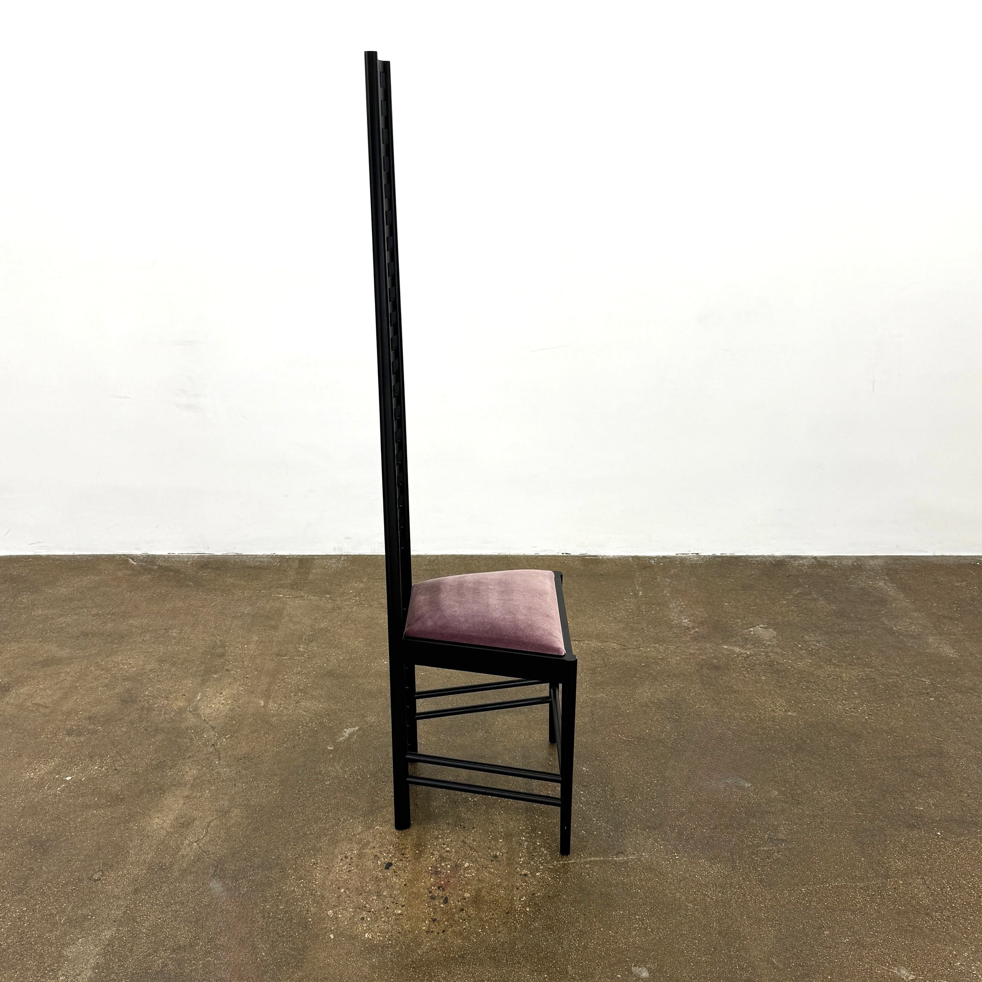 A pair of Cassina 292 Hill House Chairs by Charles R. Mackintosh, with black slatted frames—one featuring a burgundy seat cushion, the other dark green—showcasing Cassina's modernist design against a plain white background.