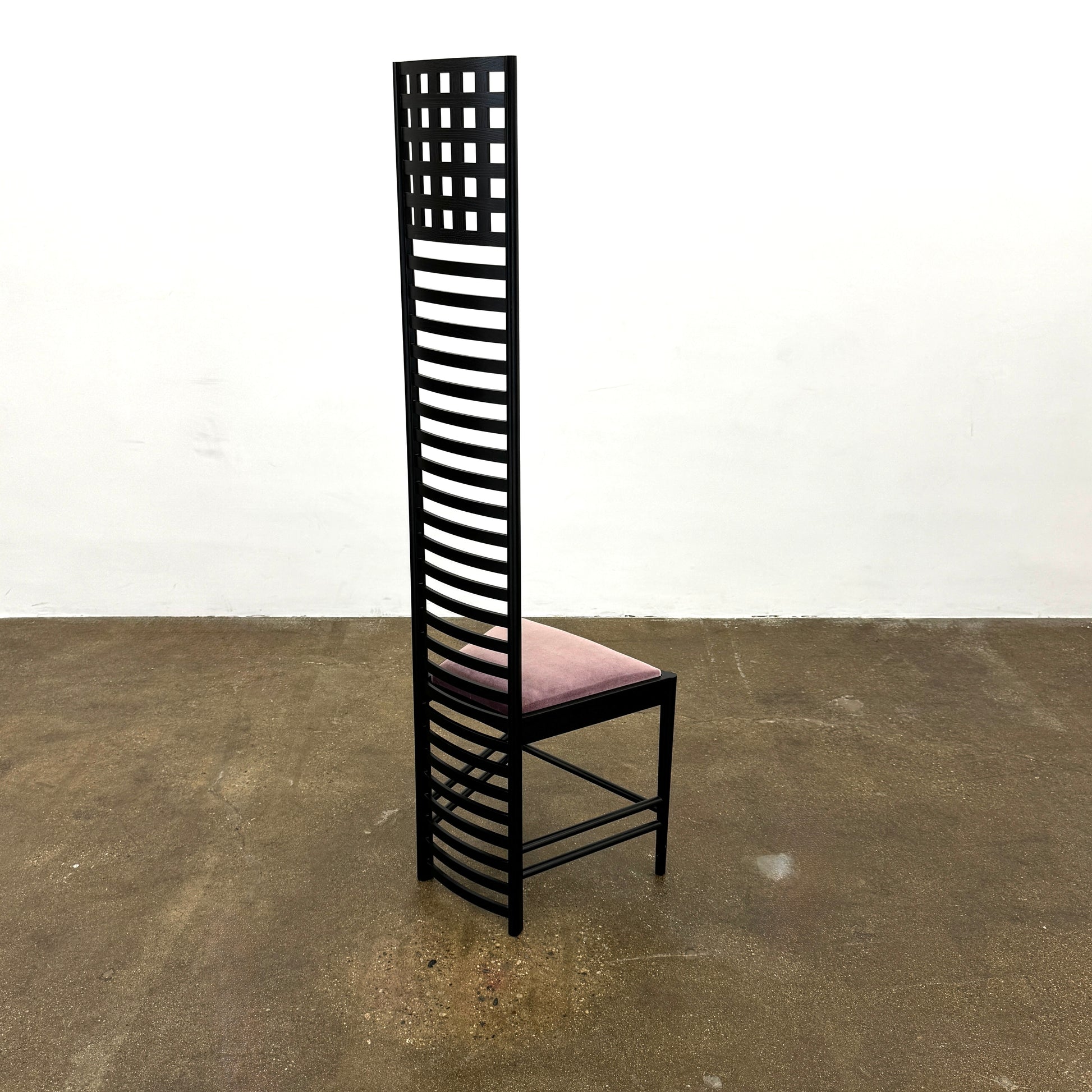 A pair of Cassina 292 Hill House Chairs by Charles R. Mackintosh, with black slatted frames—one featuring a burgundy seat cushion, the other dark green—showcasing Cassina's modernist design against a plain white background.