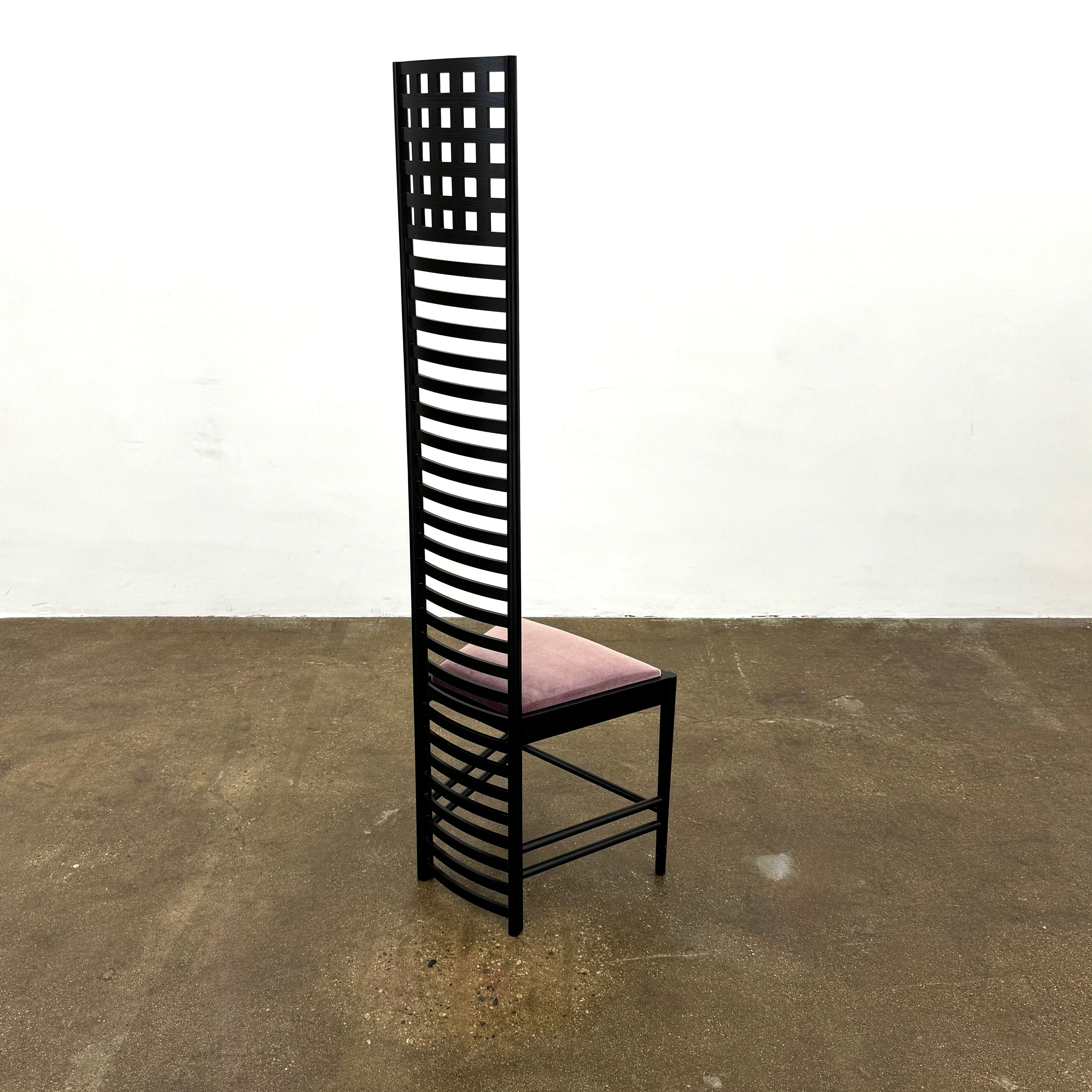 A pair of Cassina 292 Hill House Chairs by Charles R. Mackintosh, with black slatted frames—one featuring a burgundy seat cushion, the other dark green—showcasing Cassina's modernist design against a plain white background.