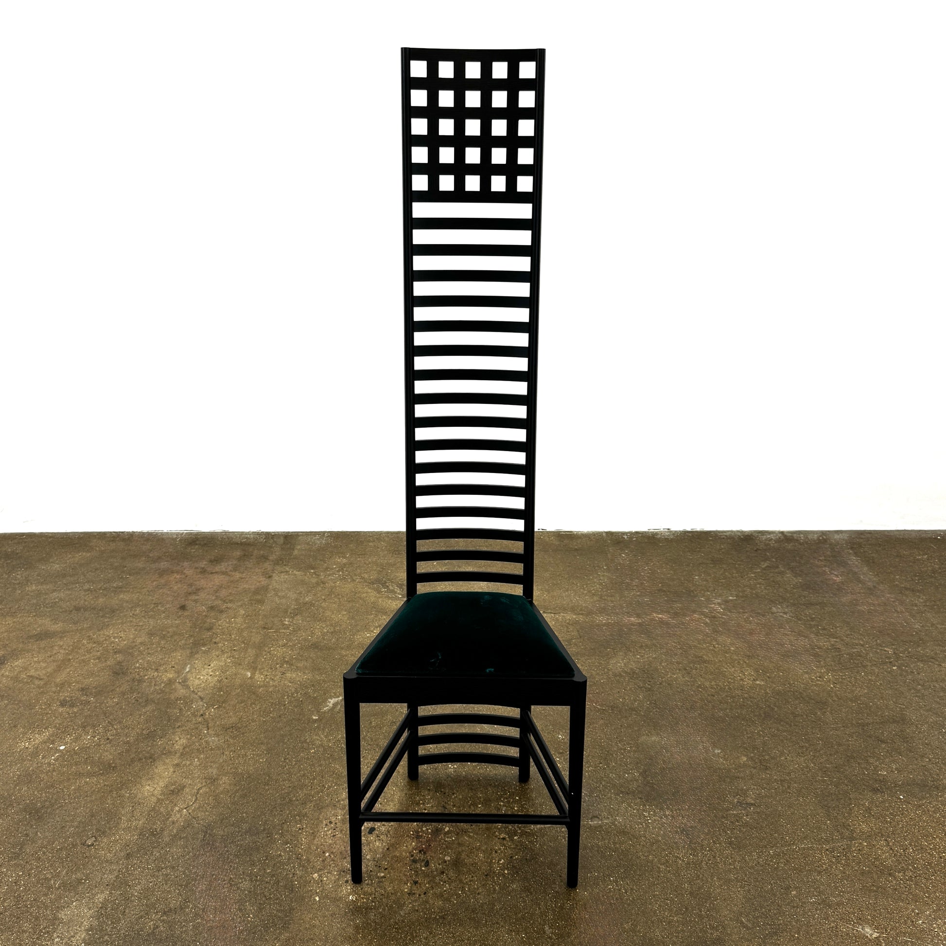A pair of Cassina 292 Hill House Chairs by Charles R. Mackintosh, with black slatted frames—one featuring a burgundy seat cushion, the other dark green—showcasing Cassina's modernist design against a plain white background.