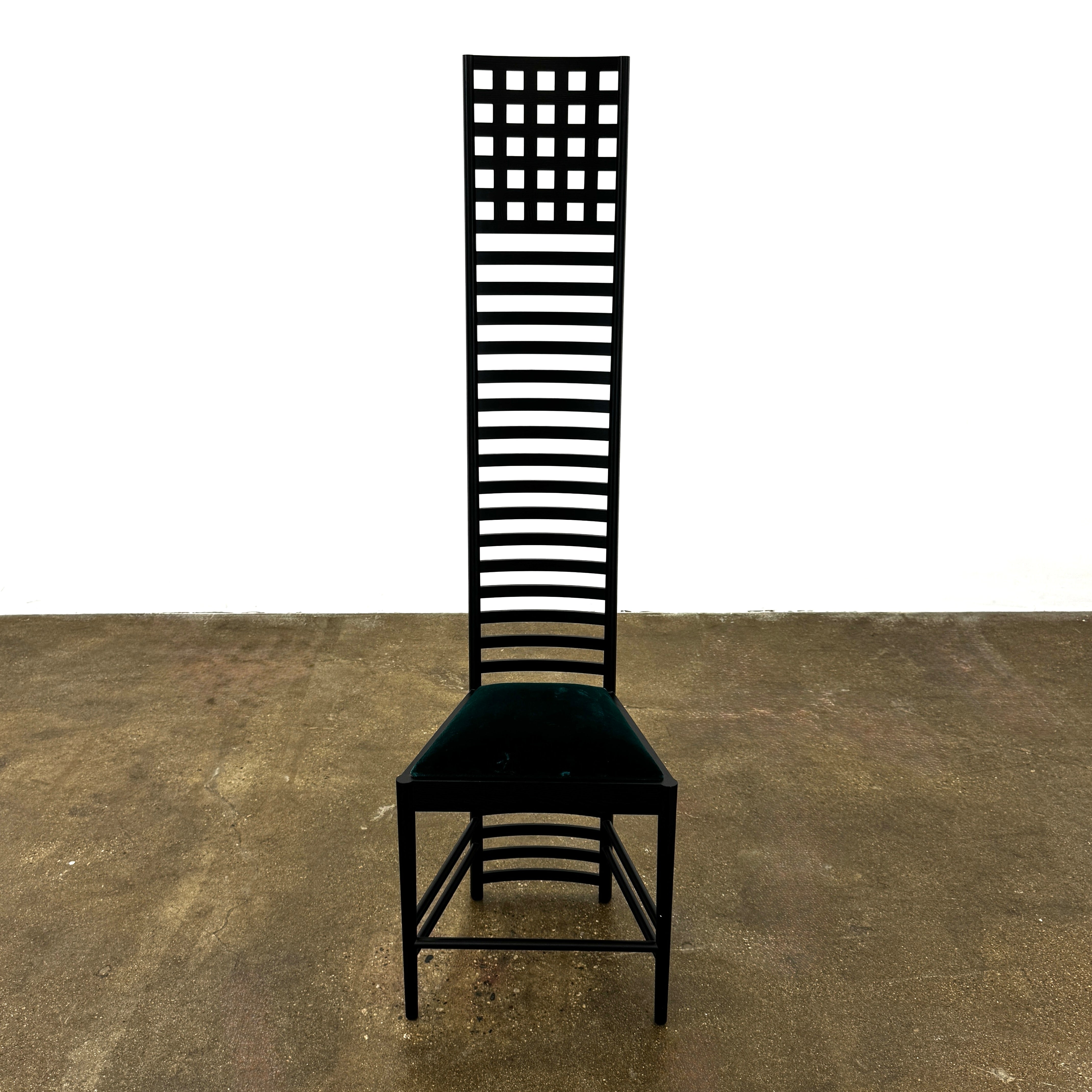 A pair of Cassina 292 Hill House Chairs by Charles R. Mackintosh, with black slatted frames—one featuring a burgundy seat cushion, the other dark green—showcasing Cassina's modernist design against a plain white background.
