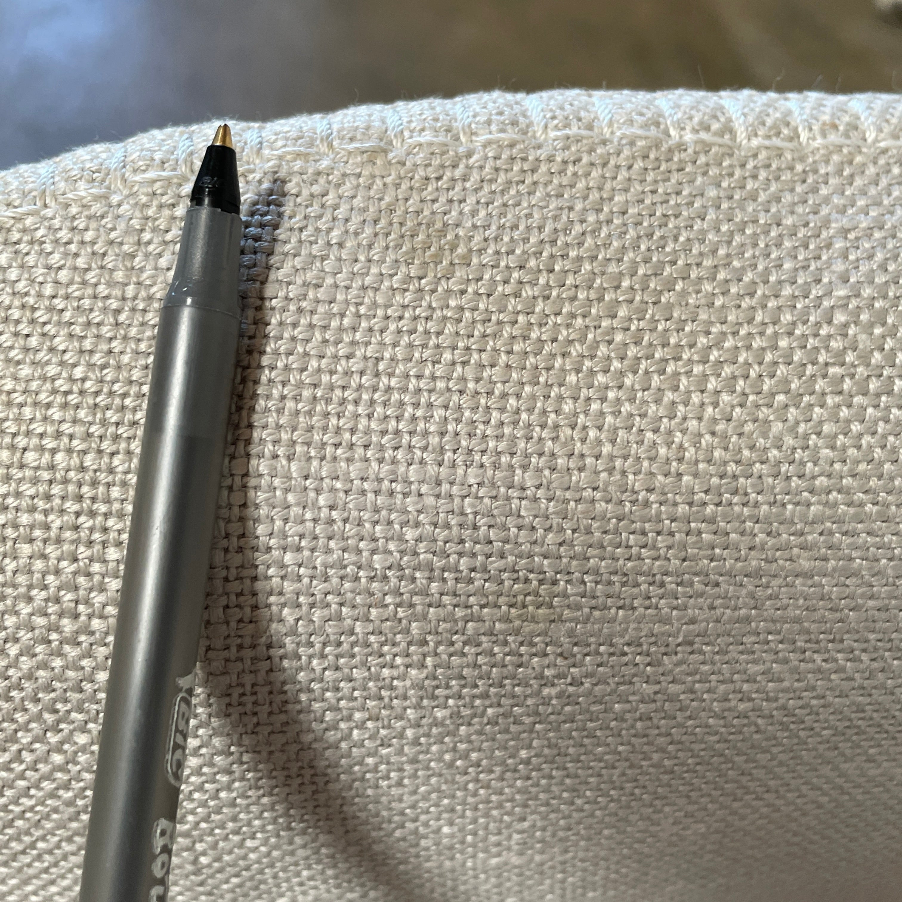 The beige upholstered chair, similar to the Maxalto Agathos Swivel Lounge Chairs, showcases a high back and a skirted bottom against a plain background.