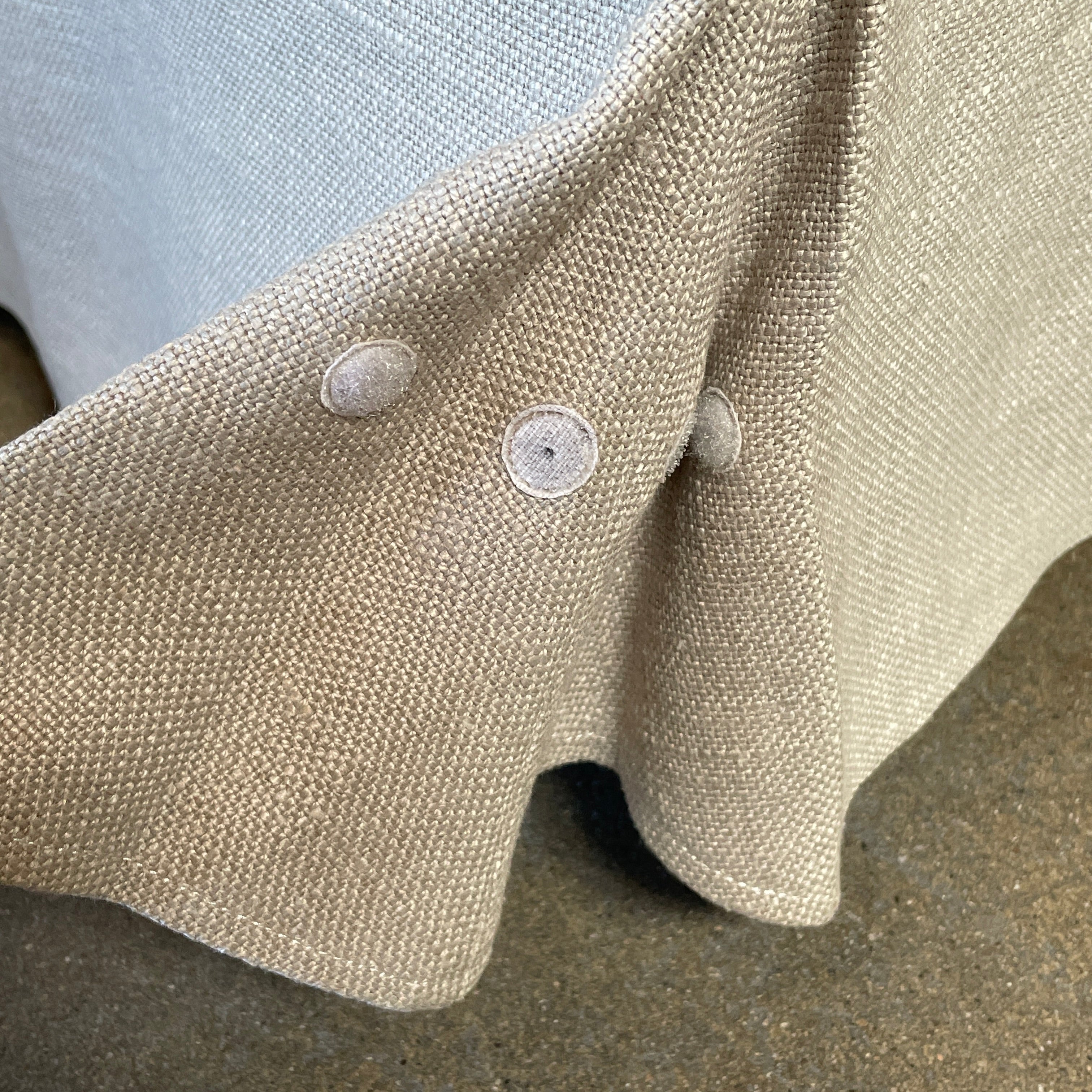 The beige upholstered chair, similar to the Maxalto Agathos Swivel Lounge Chairs, showcases a high back and a skirted bottom against a plain background.