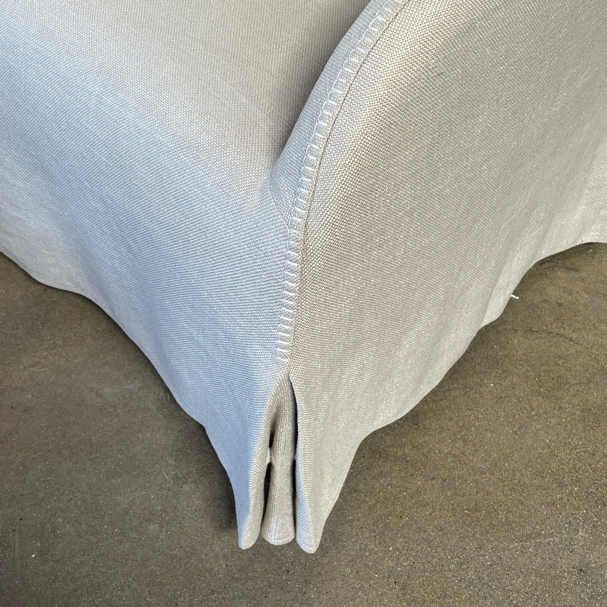 The beige upholstered chair, similar to the Maxalto Agathos Swivel Lounge Chairs, showcases a high back and a skirted bottom against a plain background.