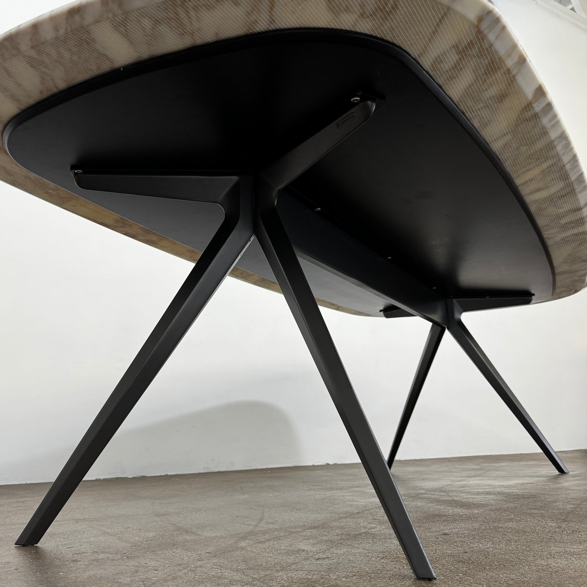 The Flexform Zefiro Dining Table by Flexform features a rectangular Calacatta Gold marble top with rounded edges and four black angled legs, shown on a plain white background.