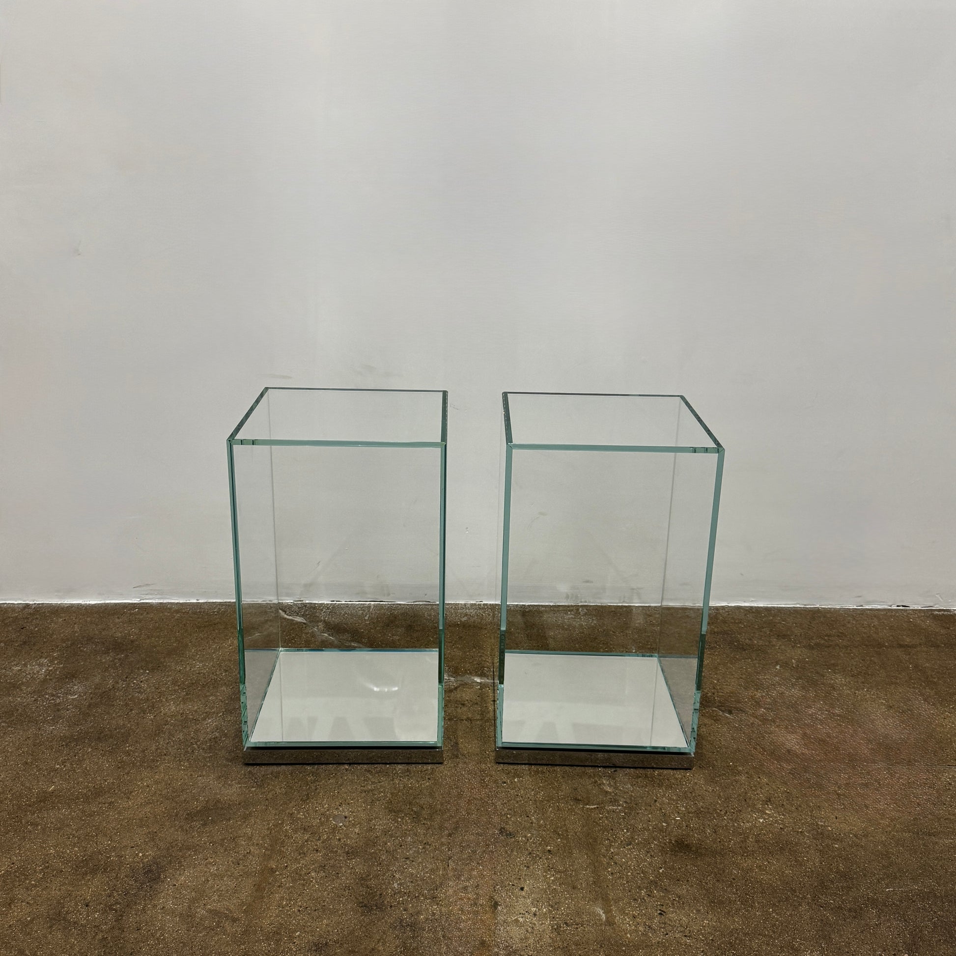 A clear rectangular glass display case with a metal base, inspired by the Cassina Volage side table Philippe Starck from Cassina, shown against a plain white background.