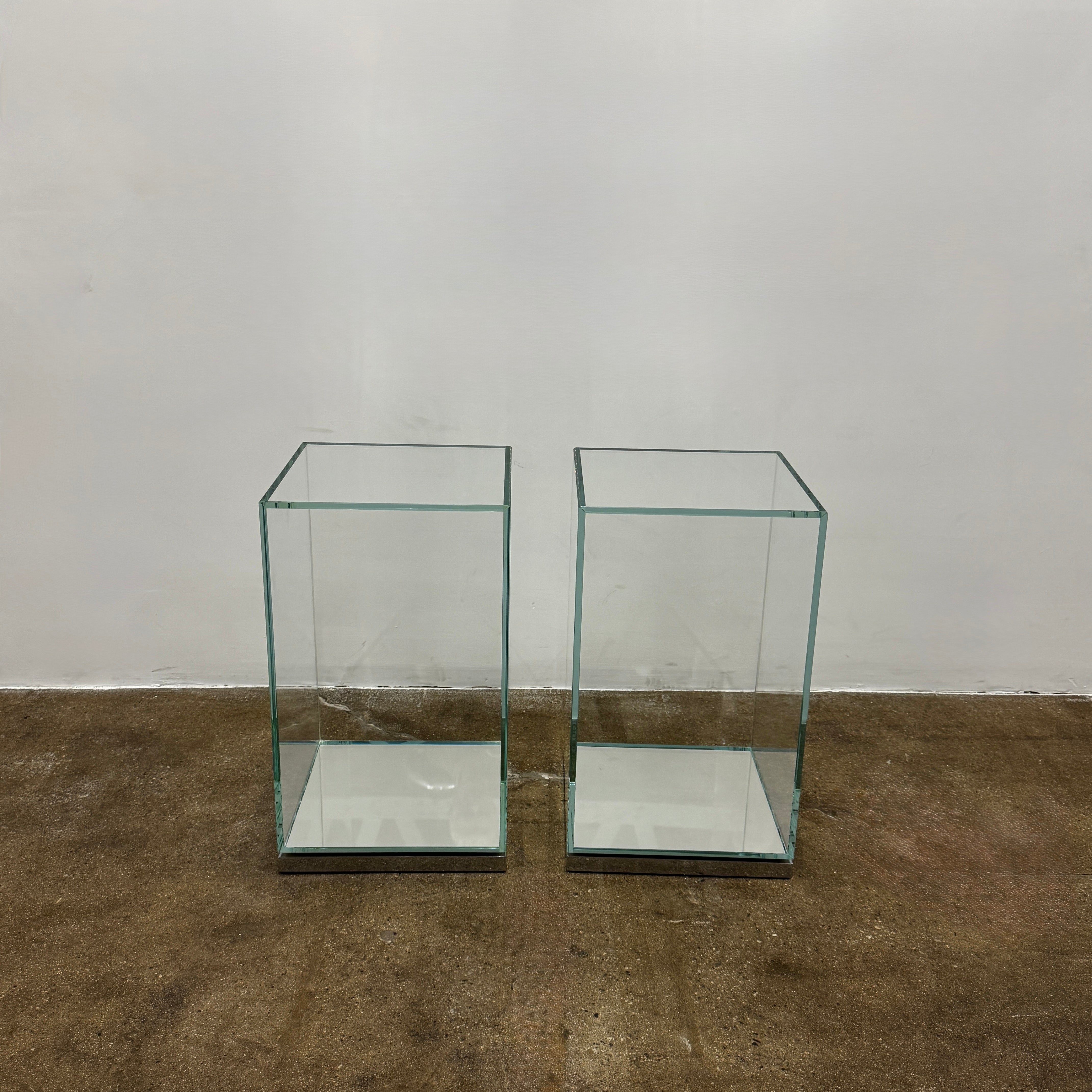 A clear rectangular glass display case with a metal base, inspired by the Cassina Volage side table Philippe Starck from Cassina, shown against a plain white background.