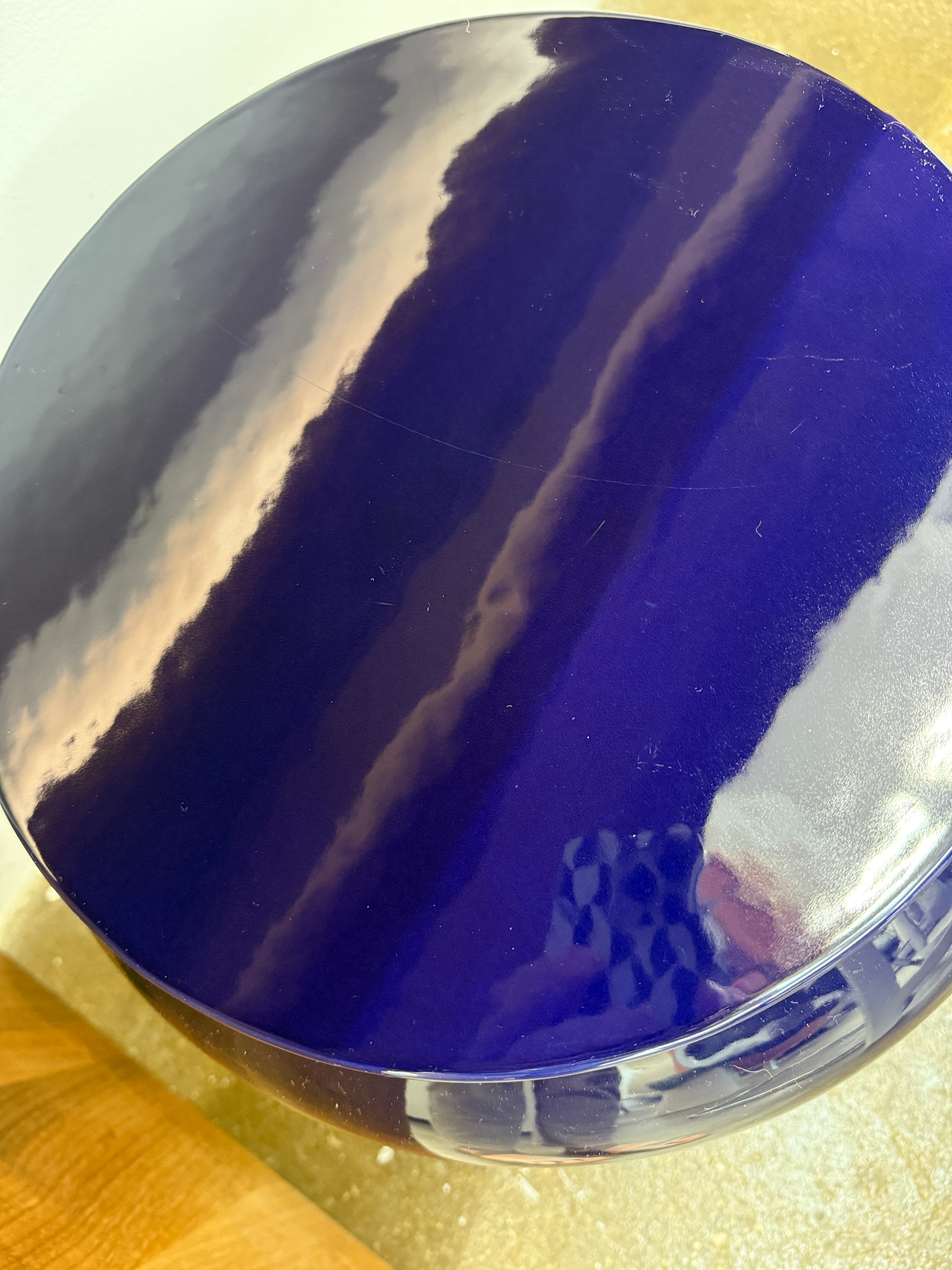 The Delcourt Collection Dot table by Delcourt Collection, designed by Charles Kalpakian, features a glossy ultramarine blue glaze and a dark blue cylindrical form with a wide, rounded top edge, set against a plain white background.