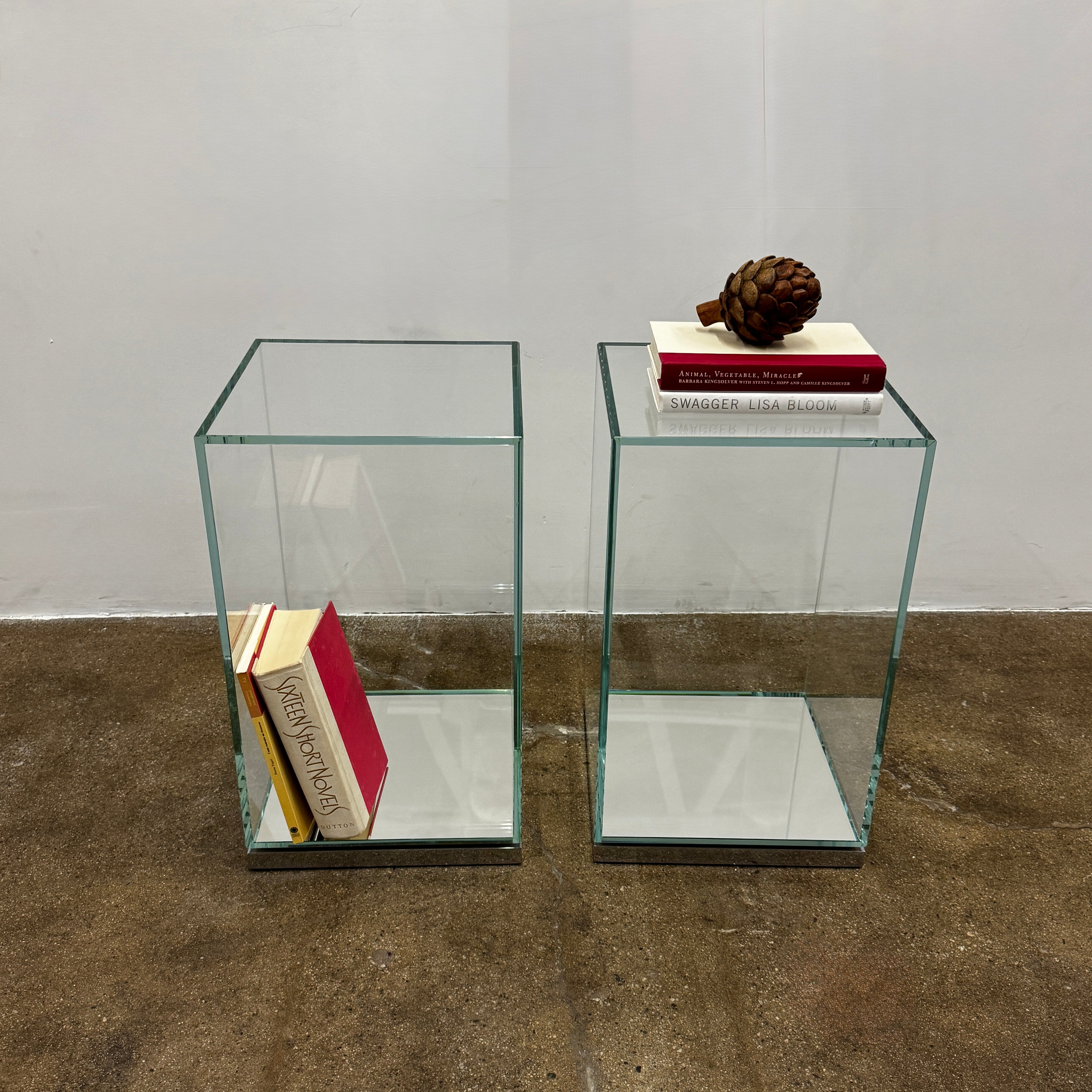 A clear glass rectangular display case with a flat metal base, inspired by the Cassina Volage side table by Philippe Starck for Cassina, photographed against a plain white background.