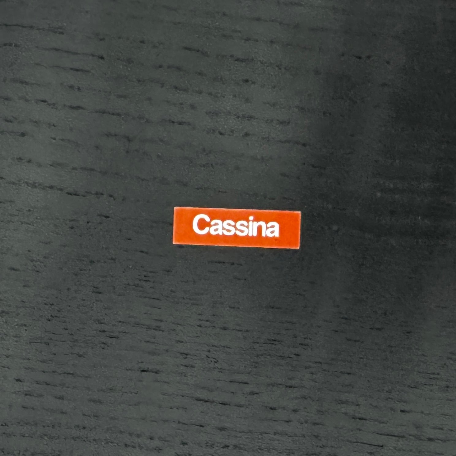 A minimalist black bench with a rectangular seat and slim metal legs echoes the elegant design of the Cassina Torei Occasional Table in Black Ash by Cassina, displayed against a plain white background.