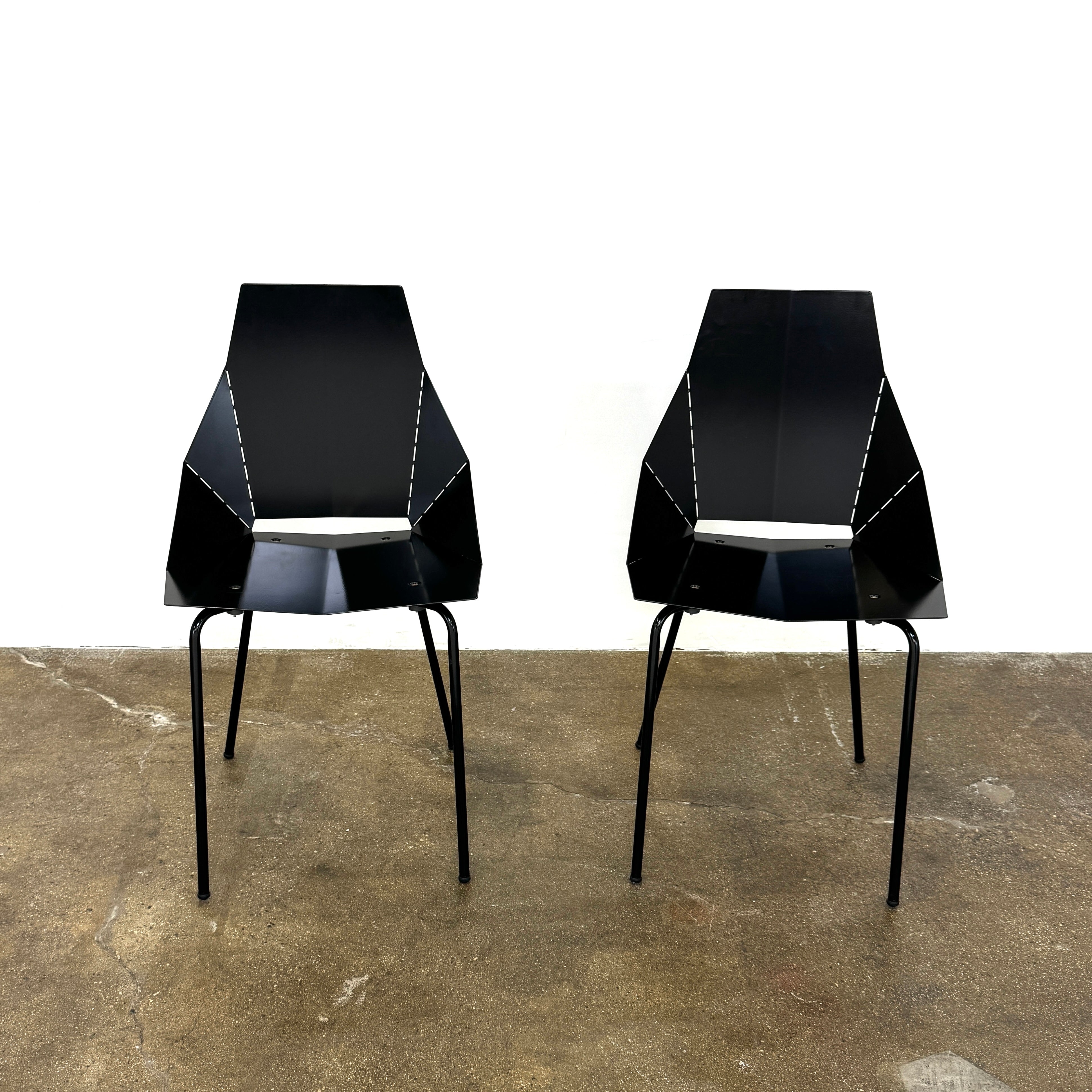 The Blu Dot “Real Good Chair” by Blu Dot is a black, angular steel chair with four metal legs and a powder-coated finish, shown against a plain white background.